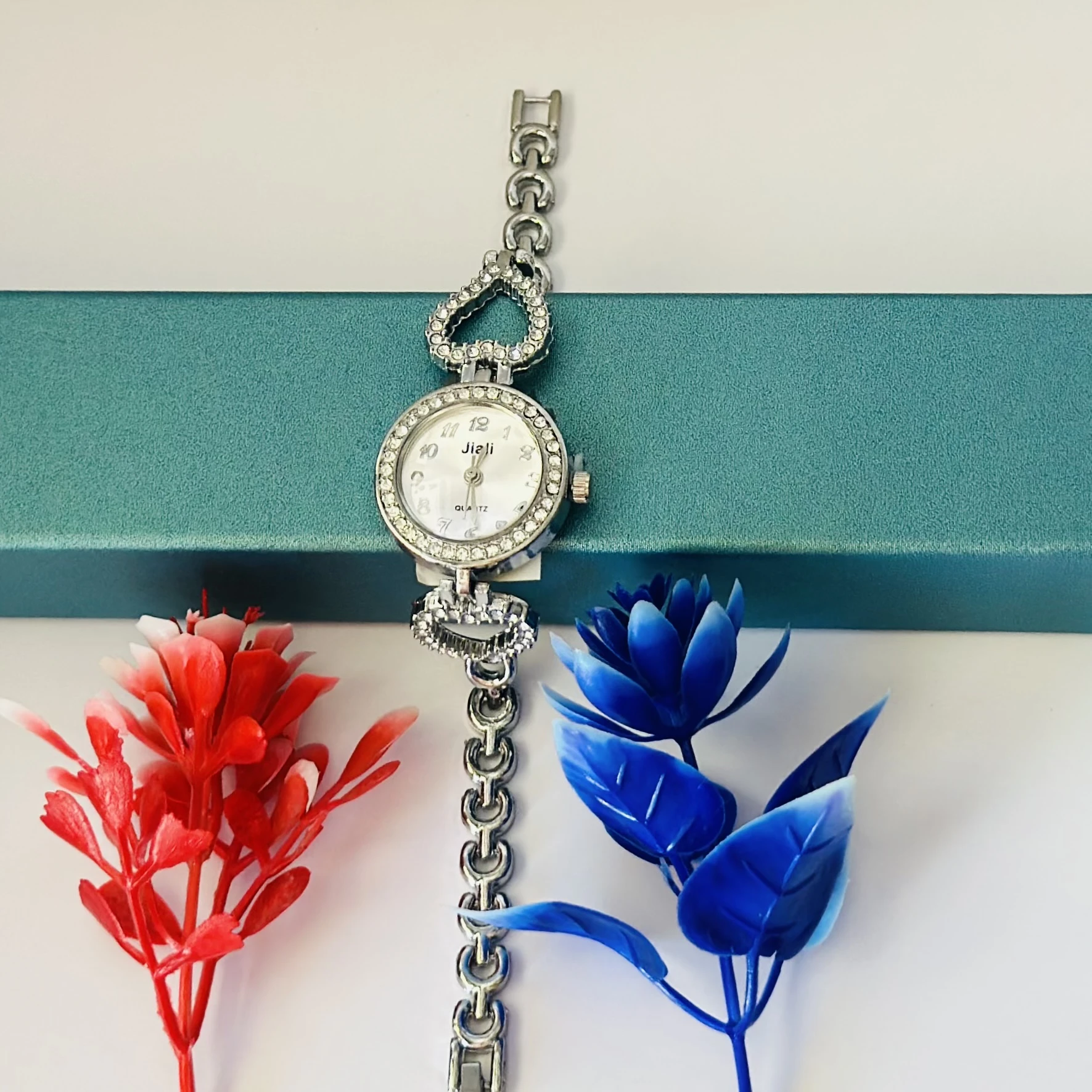 Women’s watch with a silver metal bracelet and crystal-studded bezel.