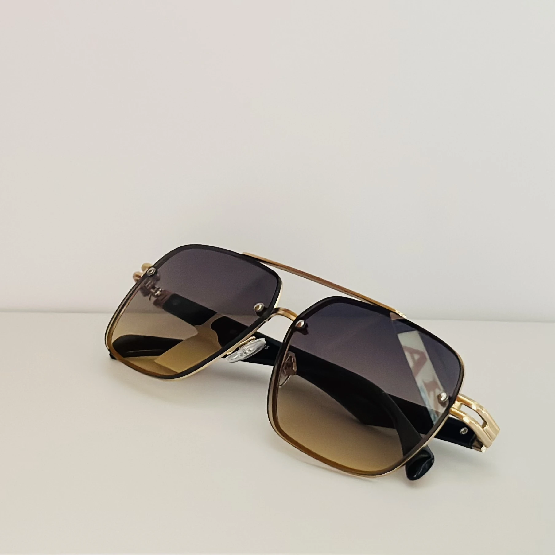 square aviator sunglasses with a gold-toned metal frame and brown gradient lenses