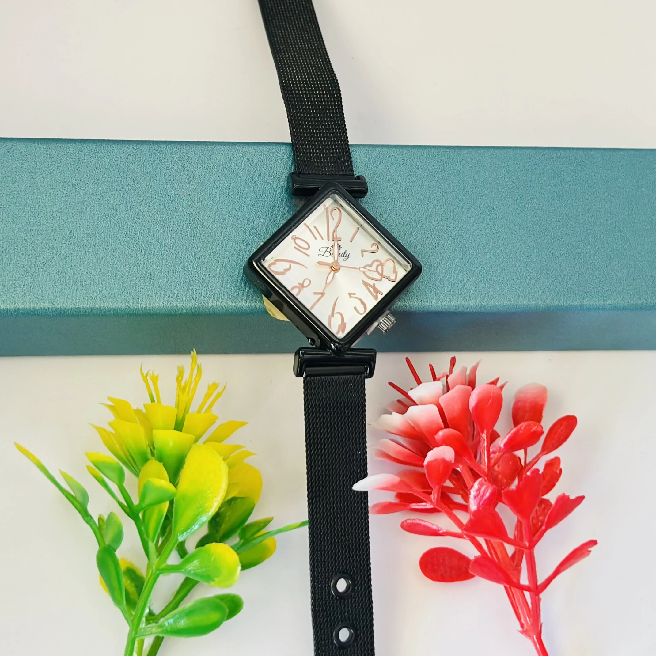 Black mesh strap watch with a square face.