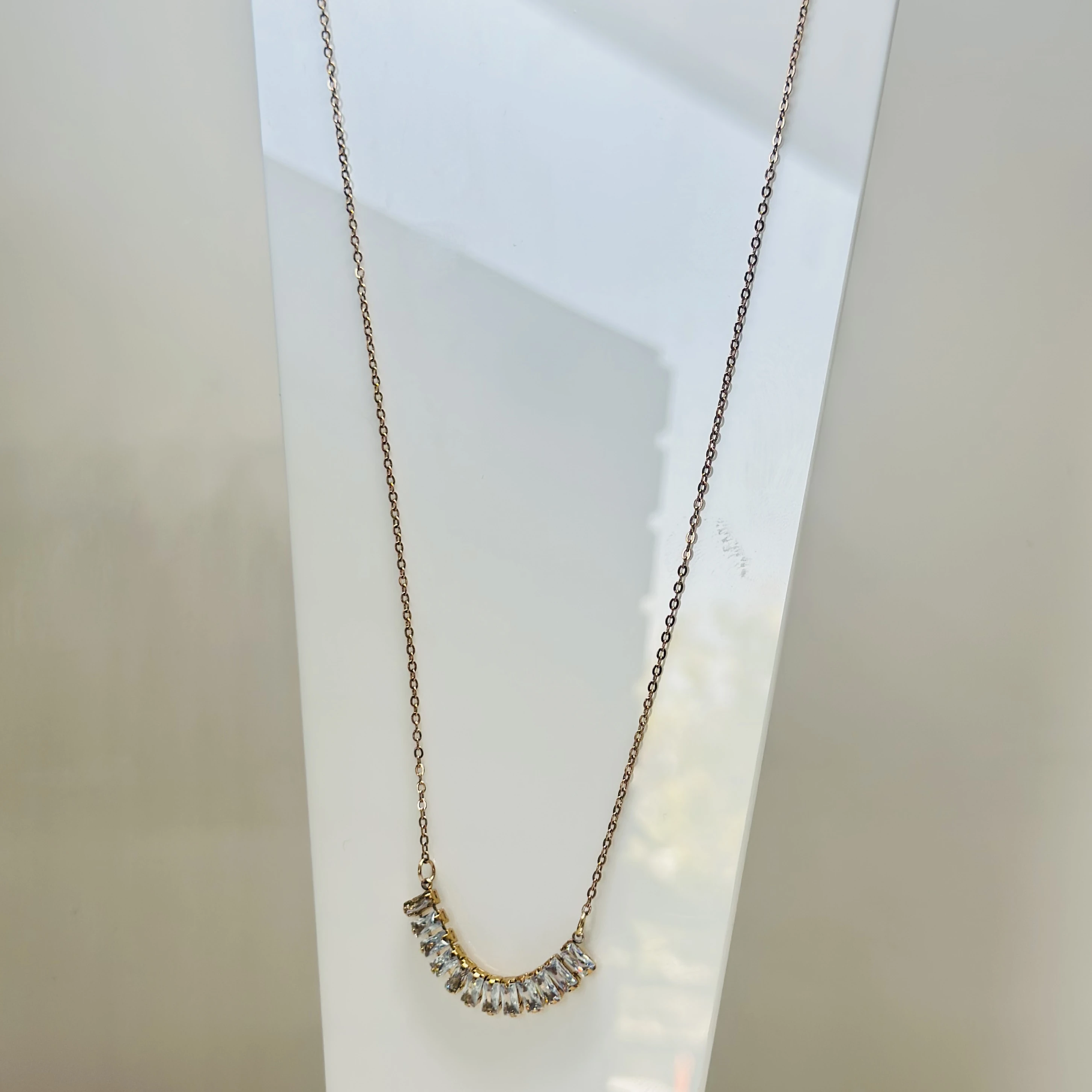 Gold  tone necklace with a curved pendant