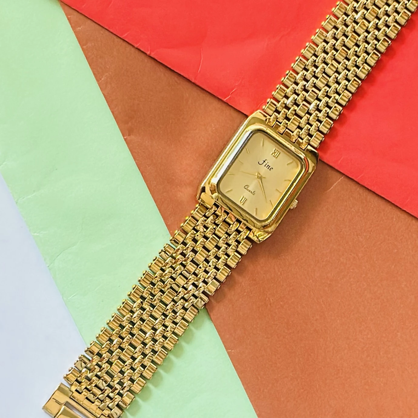 Gold -tone analog quartz watch with a metal strap.
