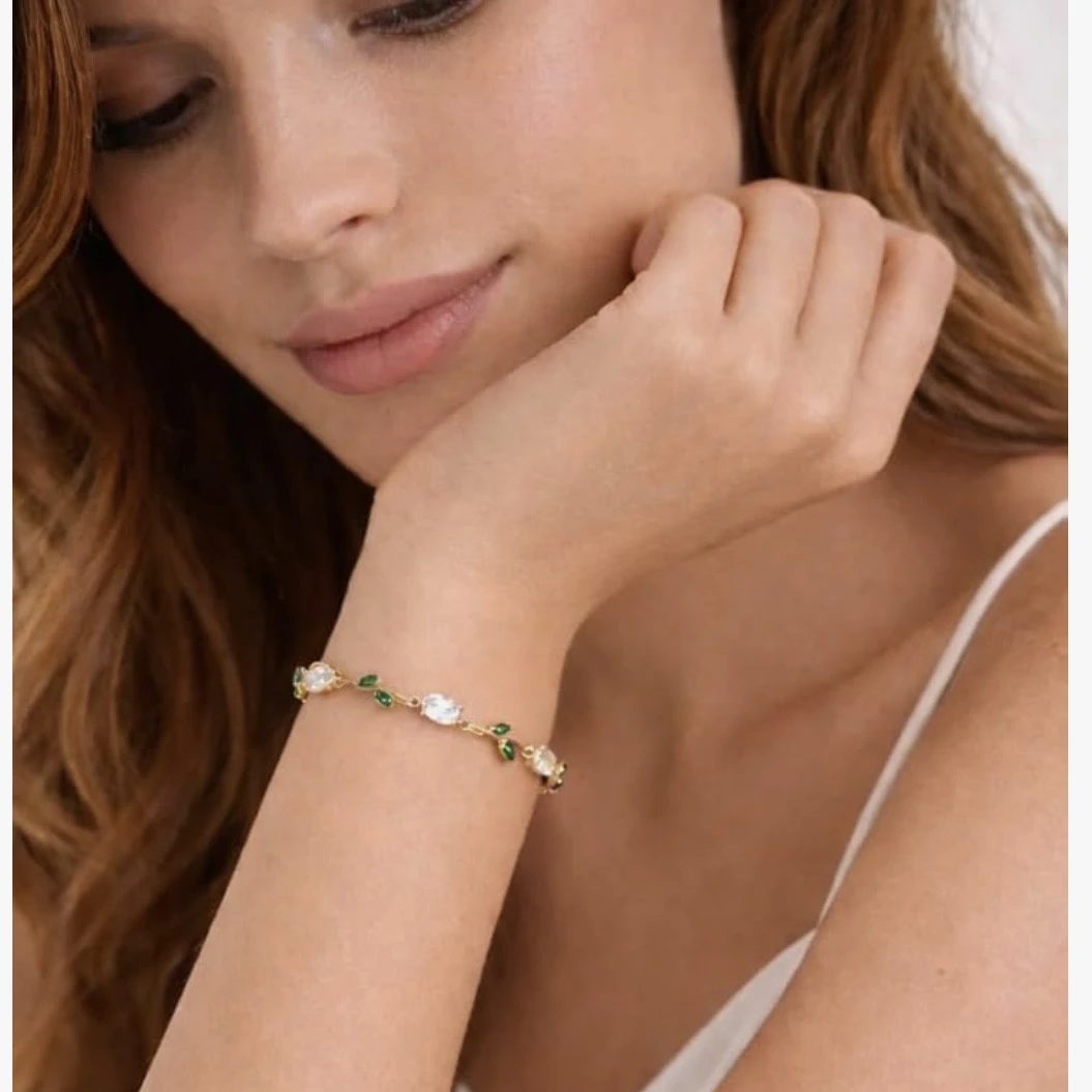 gold plated tulip bracelet featuring white oval crystals and green marquise leaf accents
