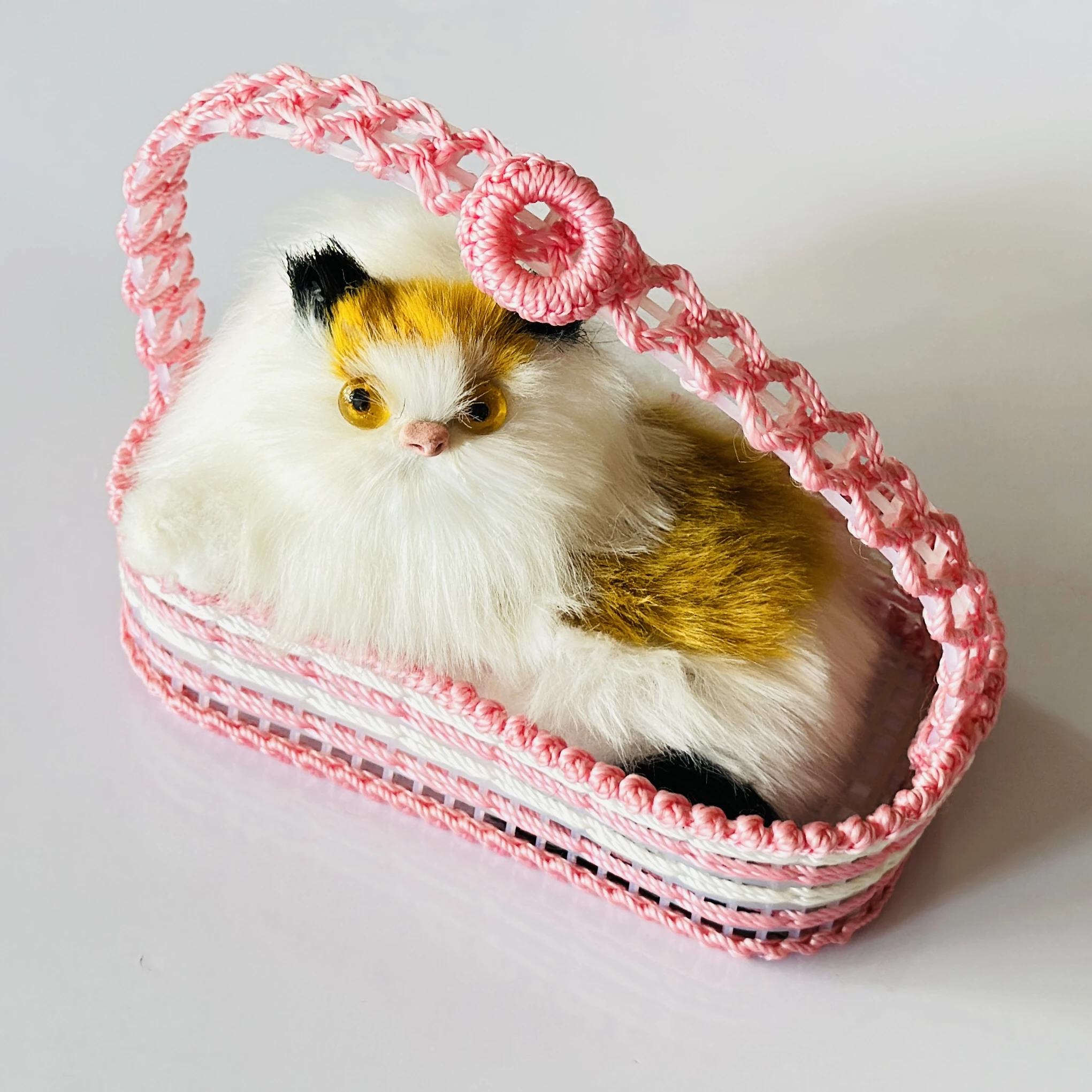 Decorative showpiece featuring a plush cat sitting inside a pink woven basket