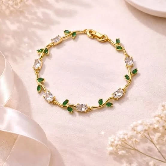 gold plated tulip bracelet featuring white oval crystals and green marquise leaf accents