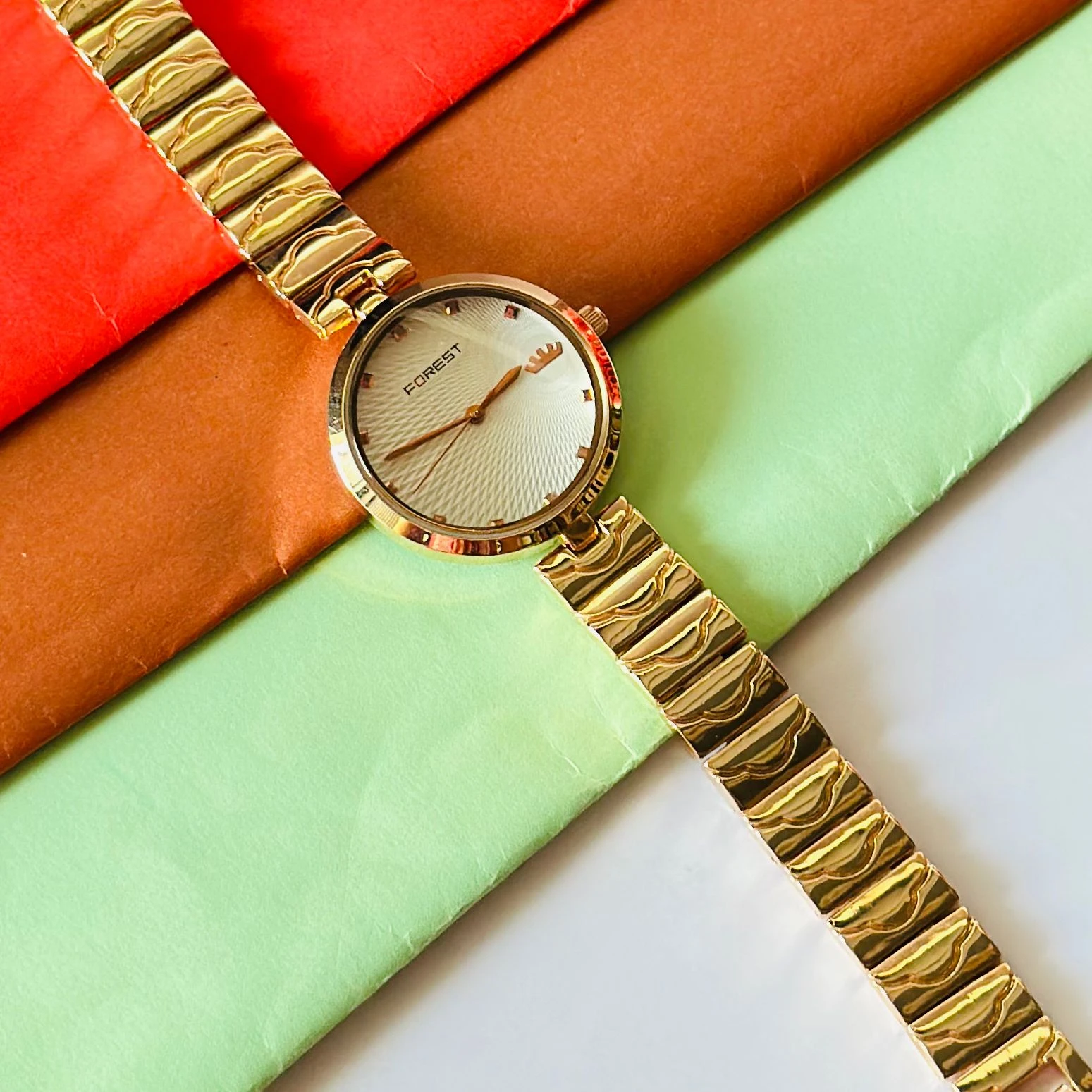 analog watch with a white dial and a rose gold metal strap