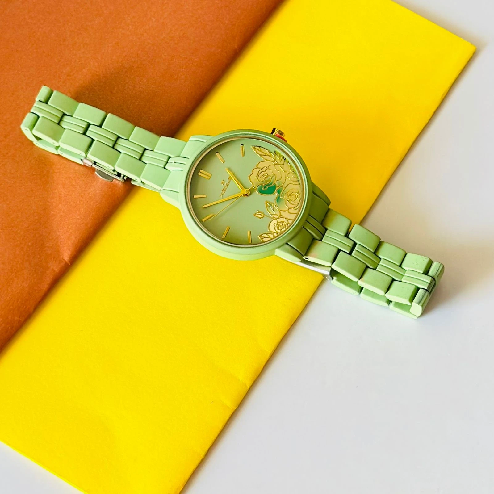 light green women's analog watch with a floral print on the dial and a link bracelet.