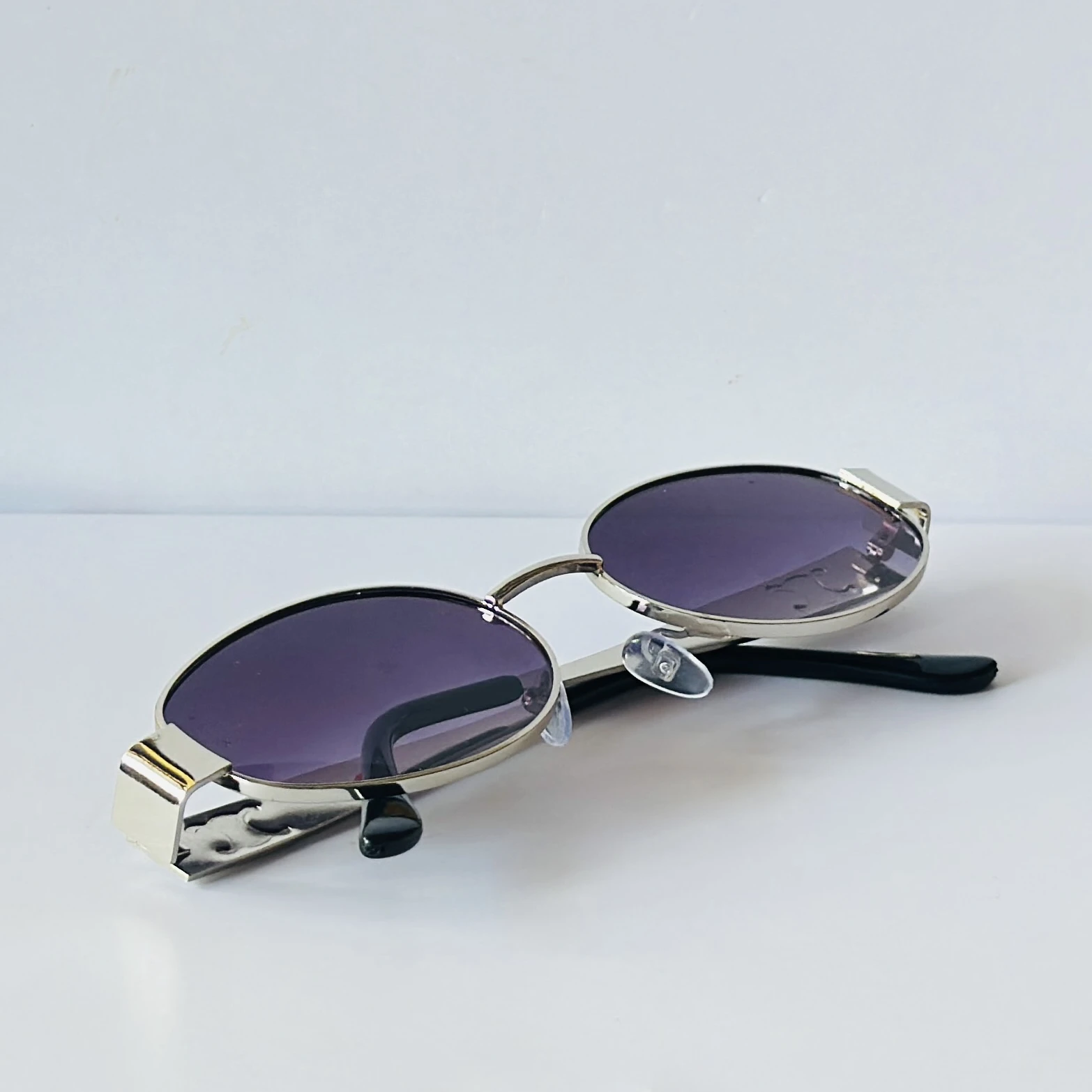 vintage-style metal sunglasses featuring purple oval lenses.