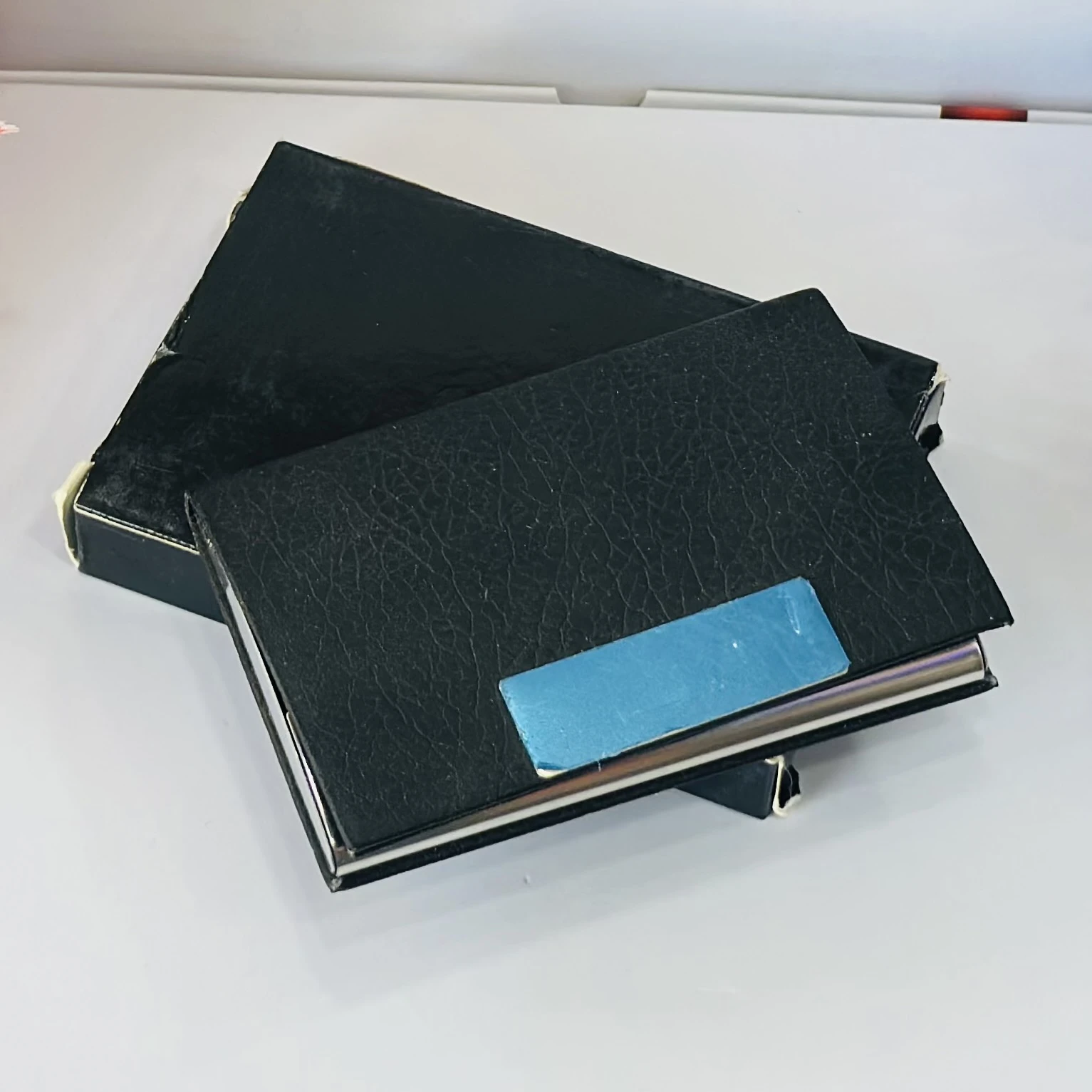 Black faux leather and metal business card holder.