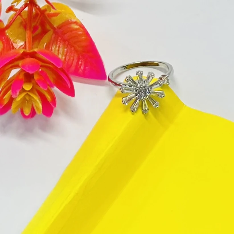 silver-plated cubic zirconia studded floral or starburst finger ring.