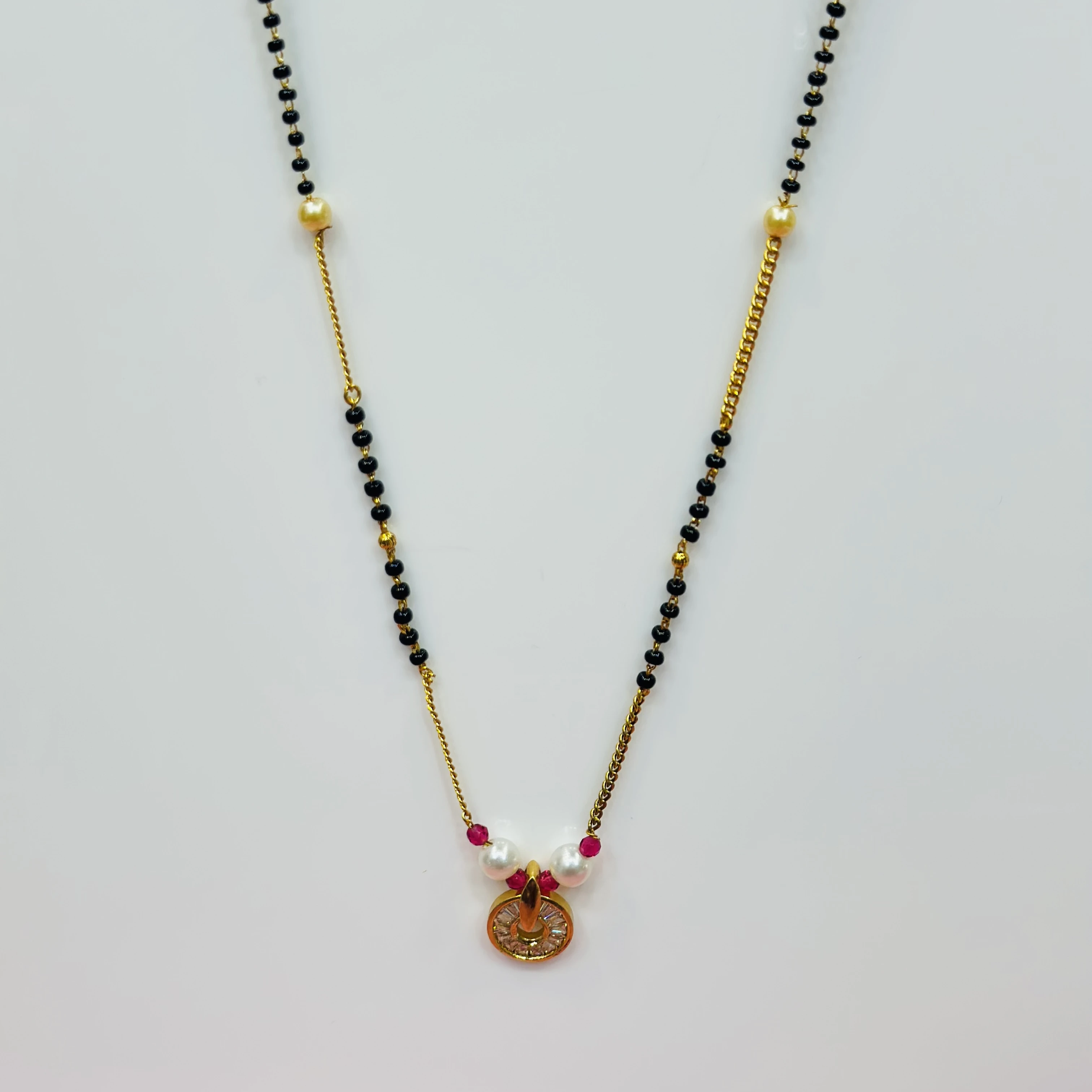 gold-plated cubic zirconia and pearl mangalsutra with red accents.