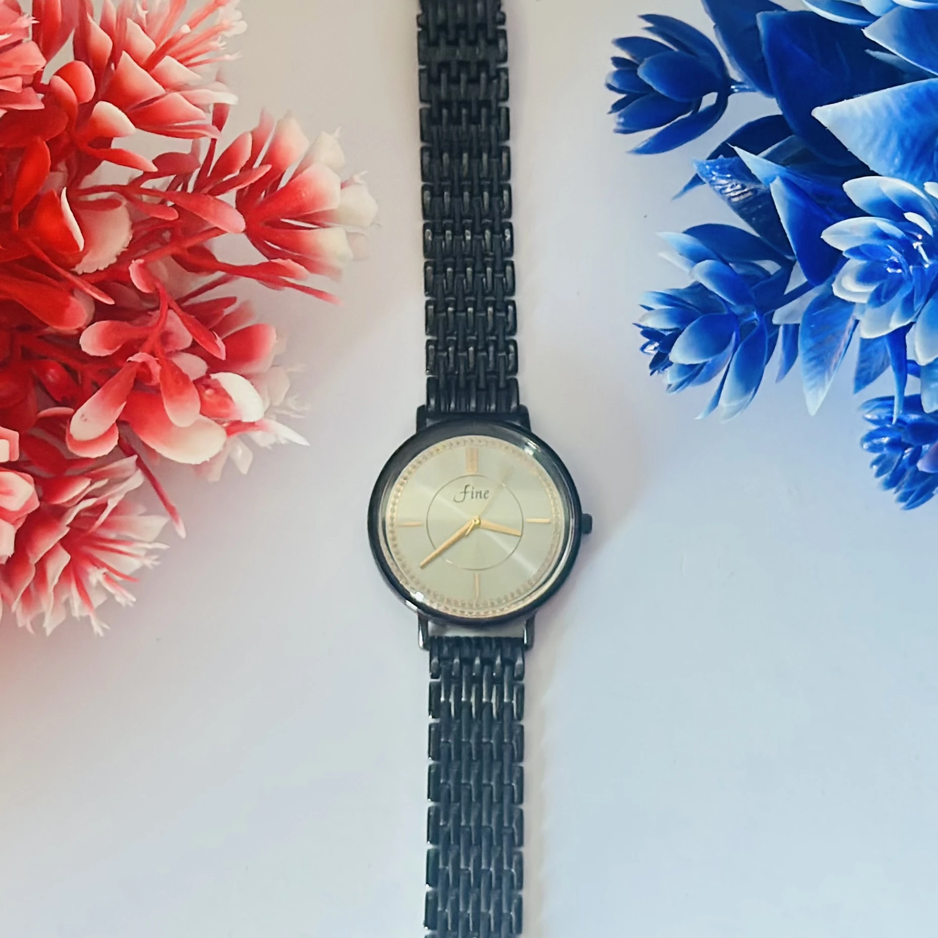 Black metal analogue women's watch with a silver dial.