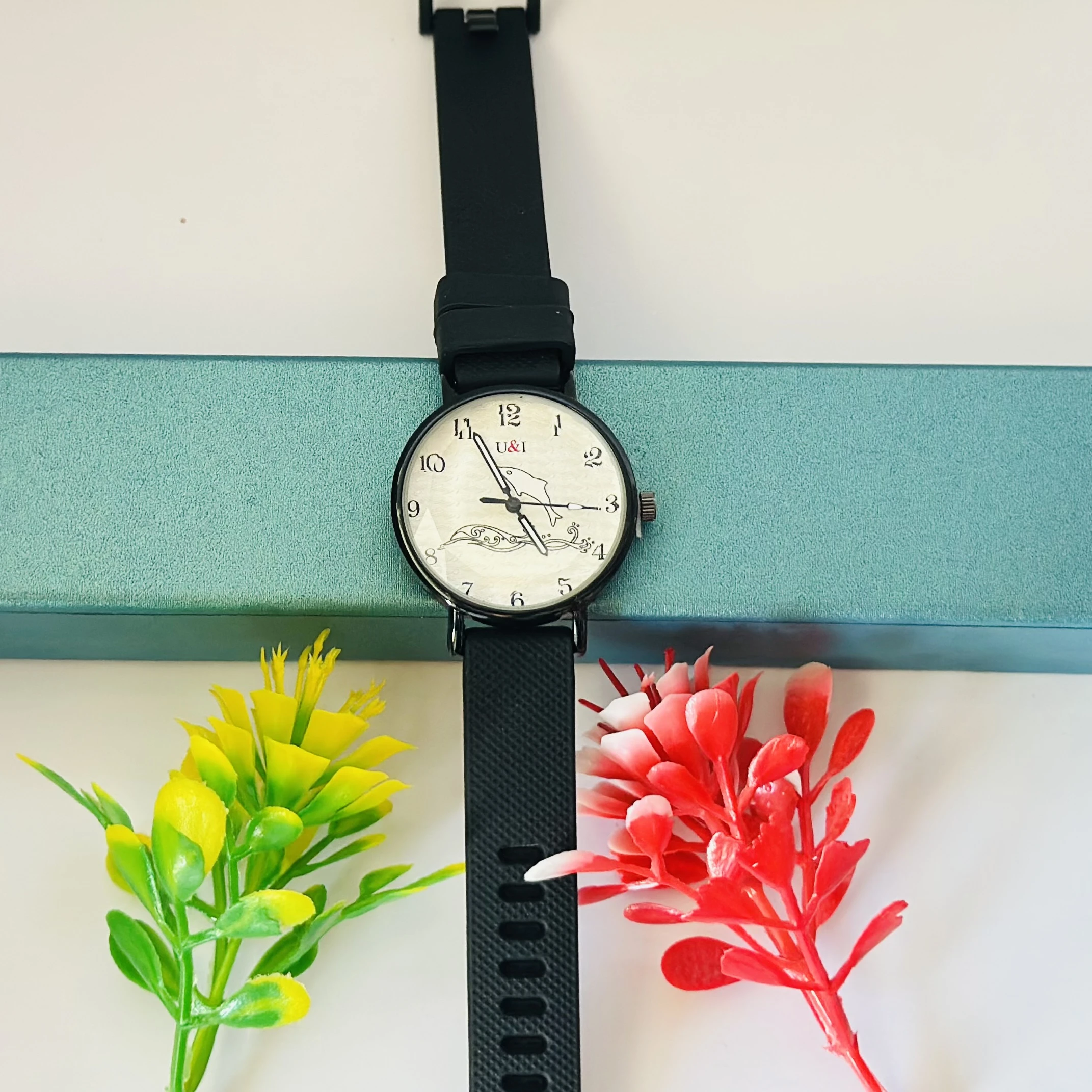 Analog wrist watch with a black rubber strap