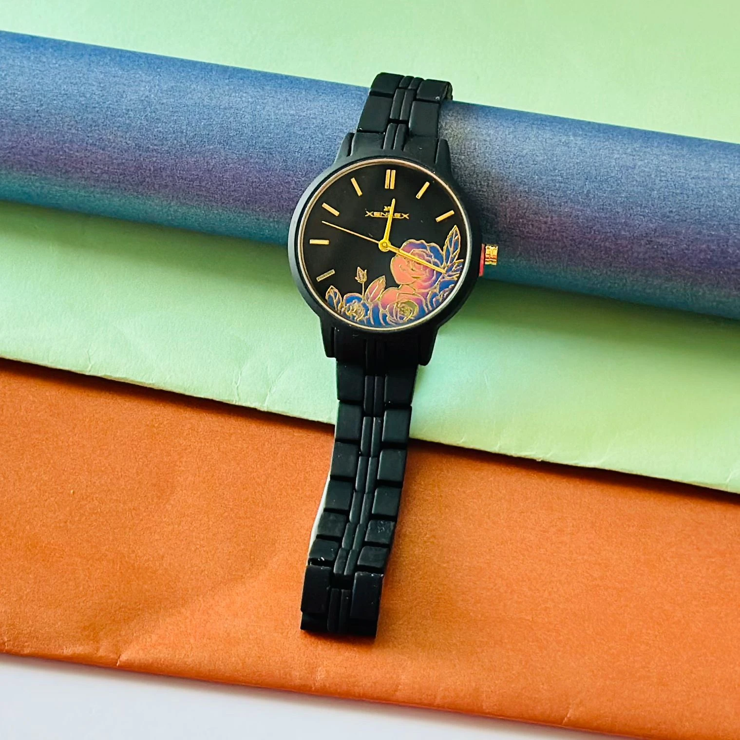 black metal analogue watch with a floral dial design