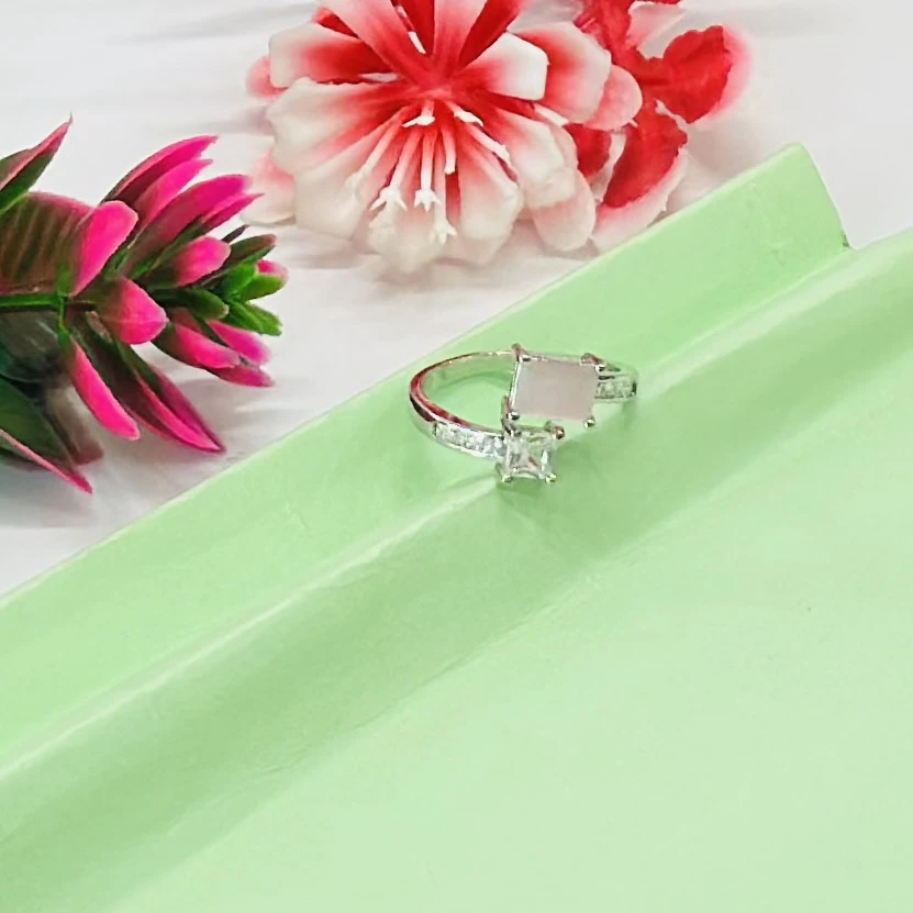 silver-toned ring featuring two prominent princess-cut stones