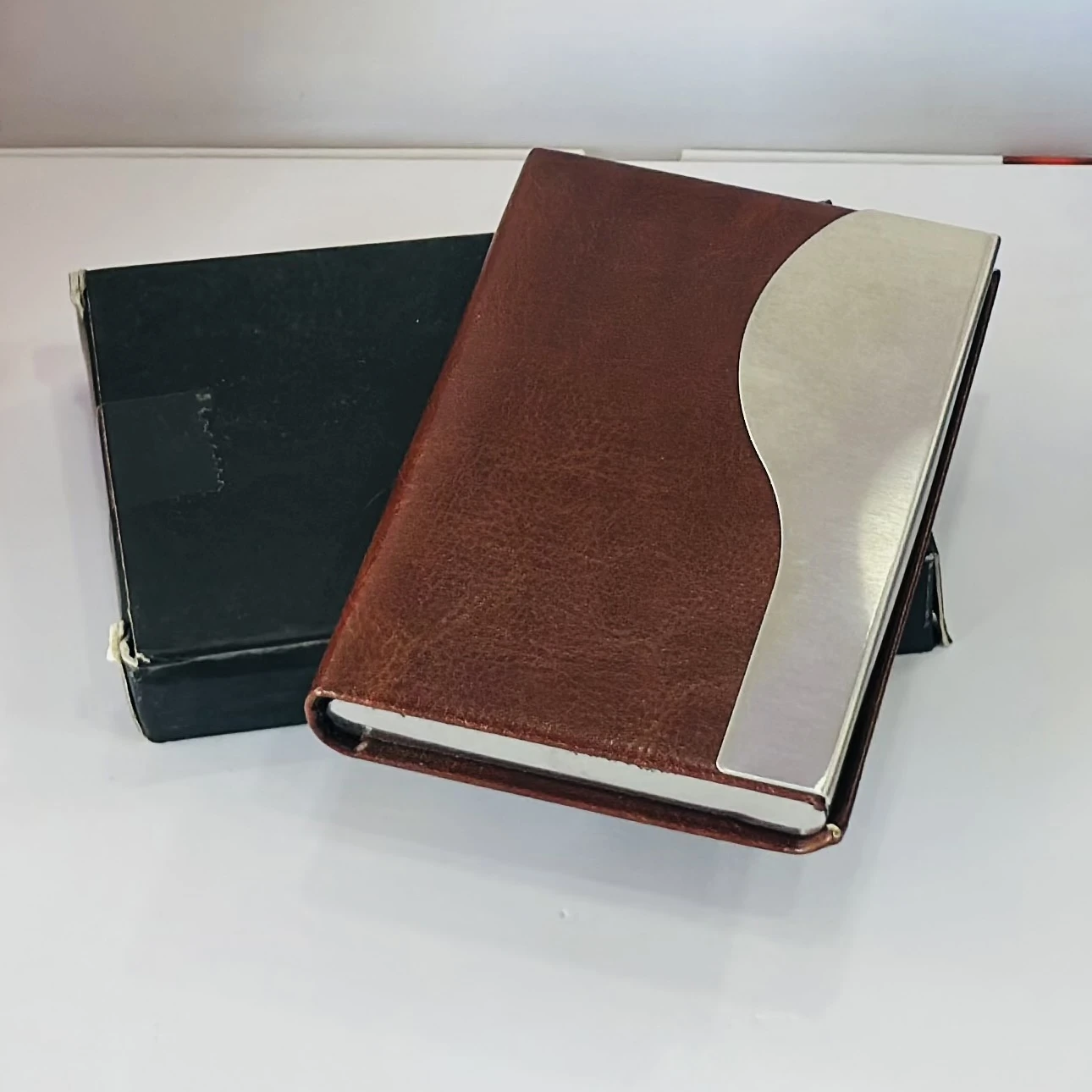 business card holder or card case, likely made of PU leather and stainless steel.