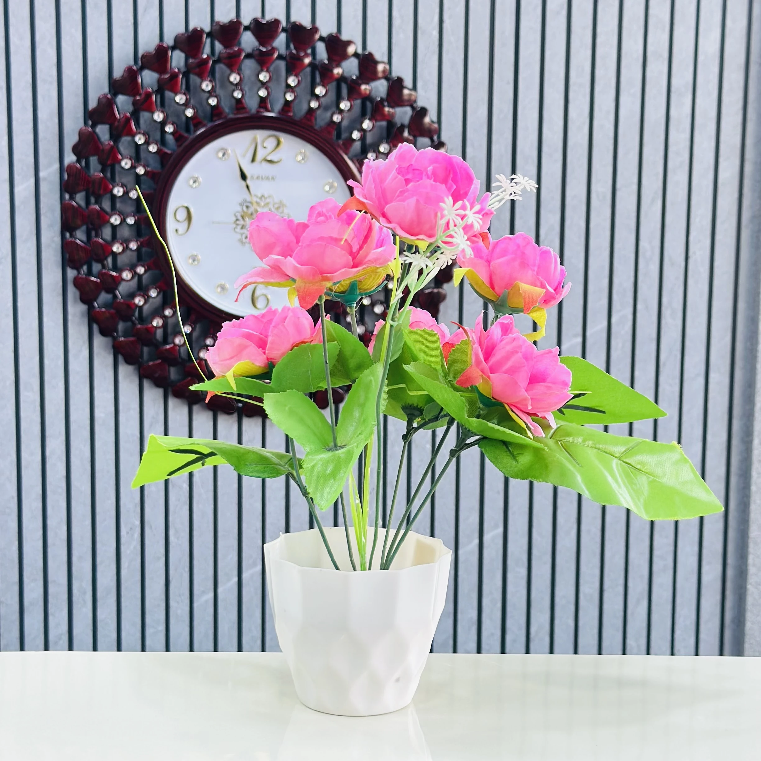 Pink  lotus flower arrangement in a white pot.