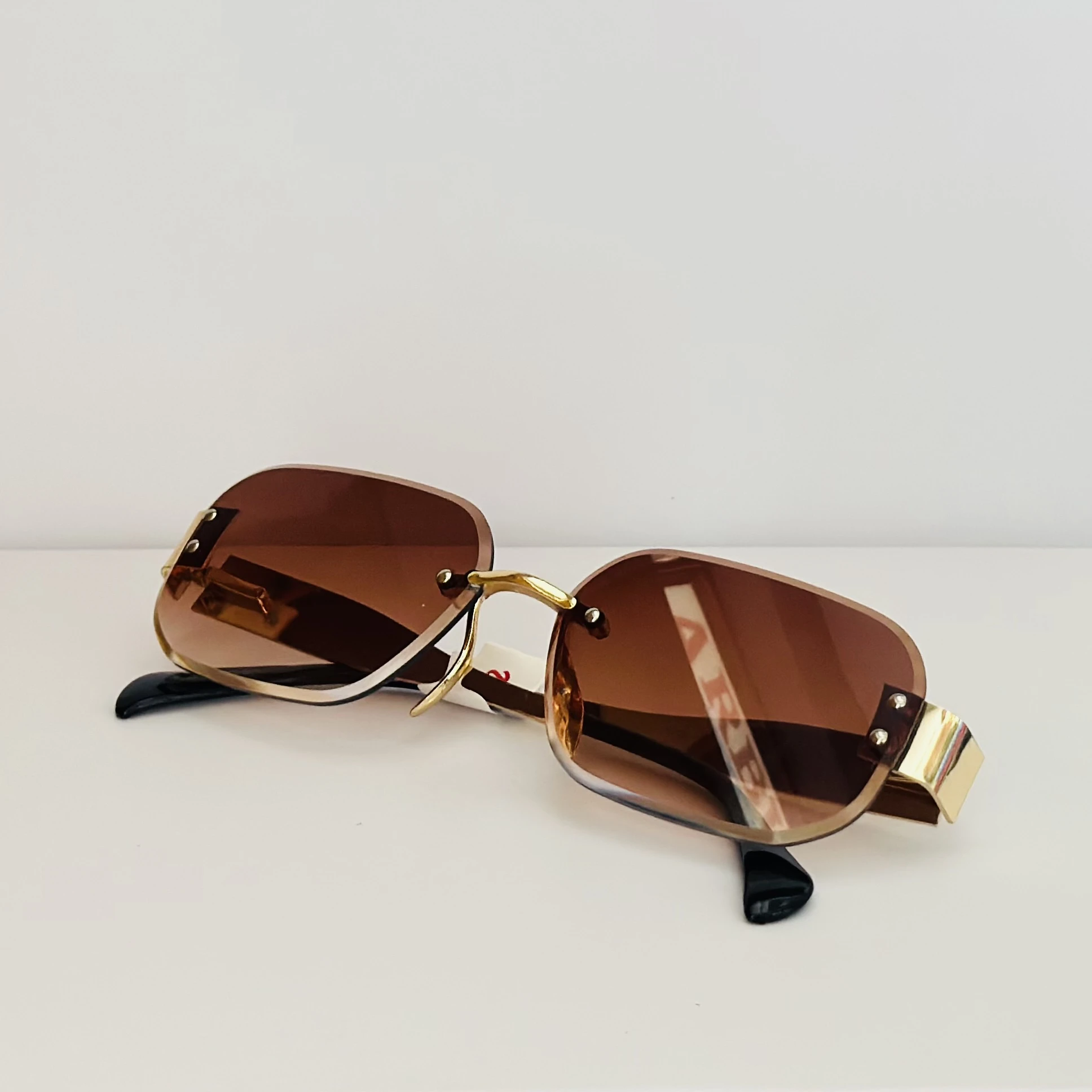 Rimless fashion sunglasses with brown gradient lenses and gold-toned hardware