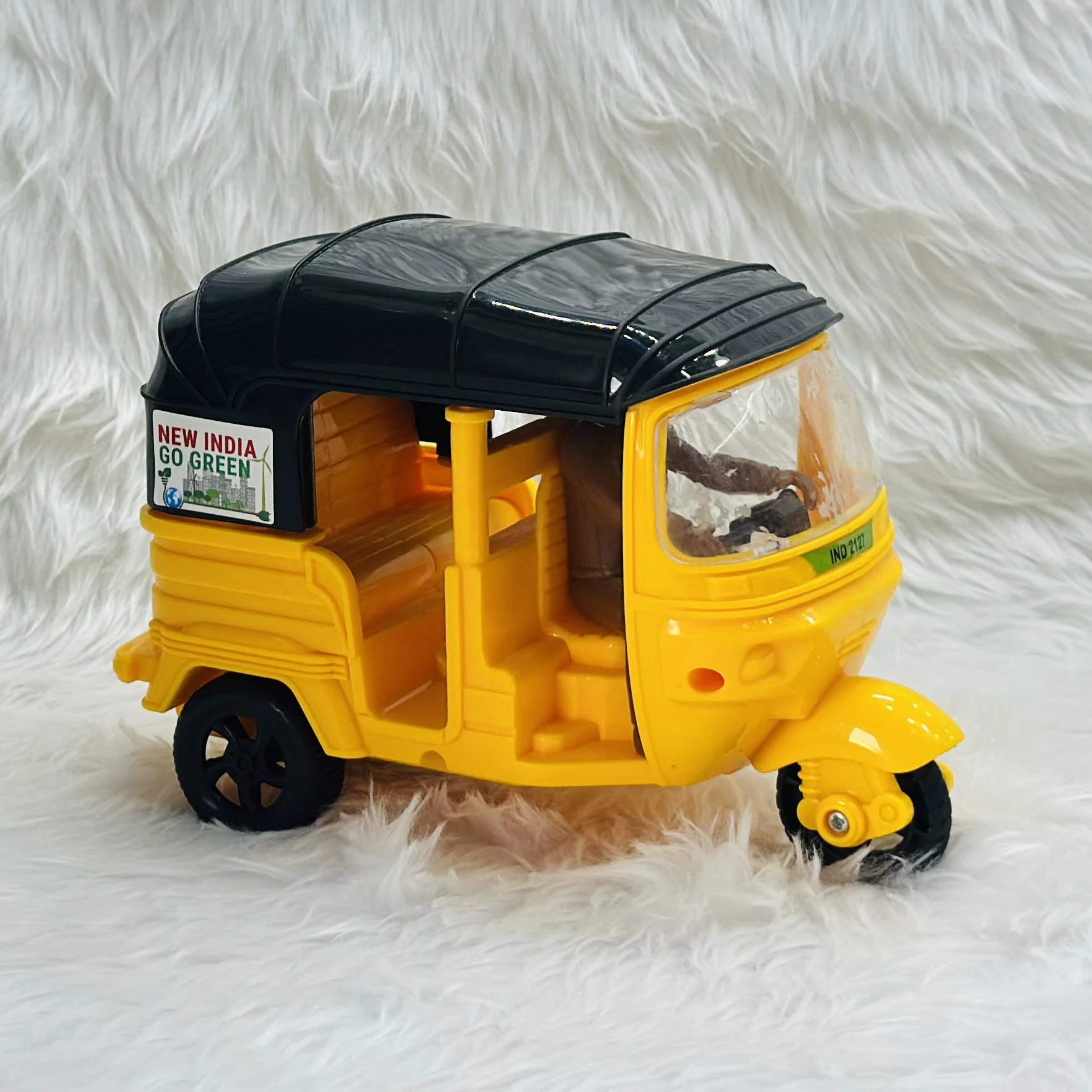 Yellow plastic toy auto rickshaw.
