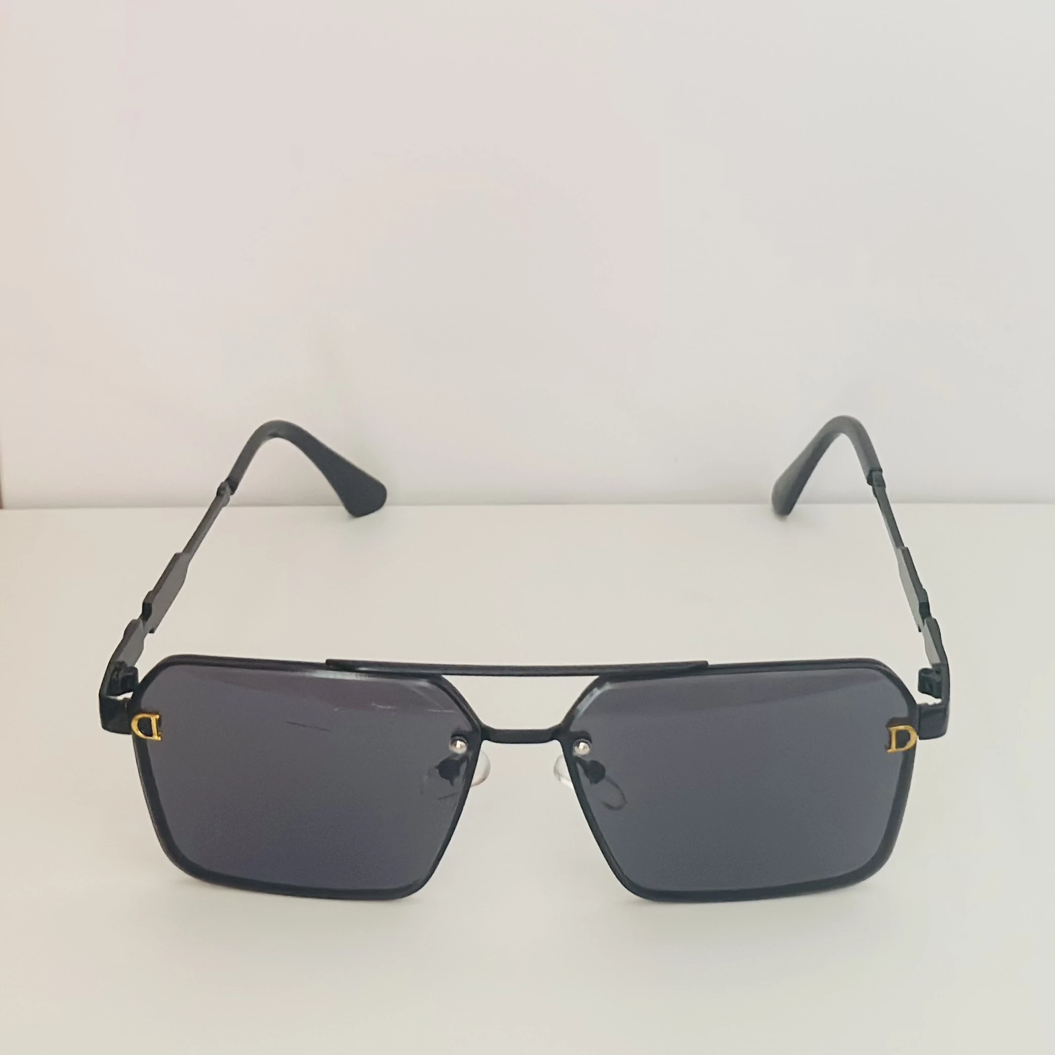 black pilot-style sunglasses with grey polycarbonate lenses.