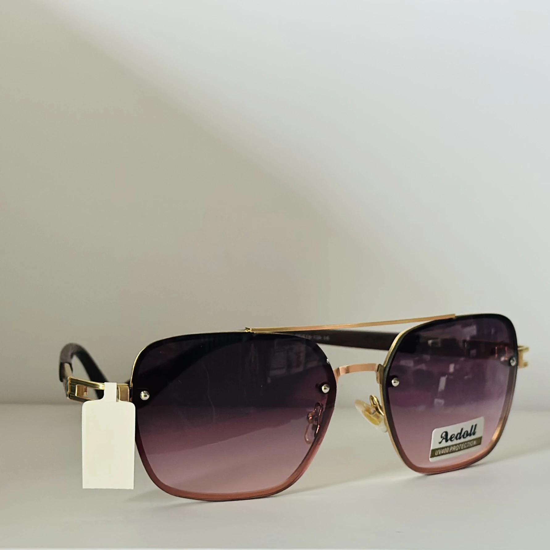 pair of Aedoll Goggle sunglasses with a gold metal frame and pink gradient lenses.