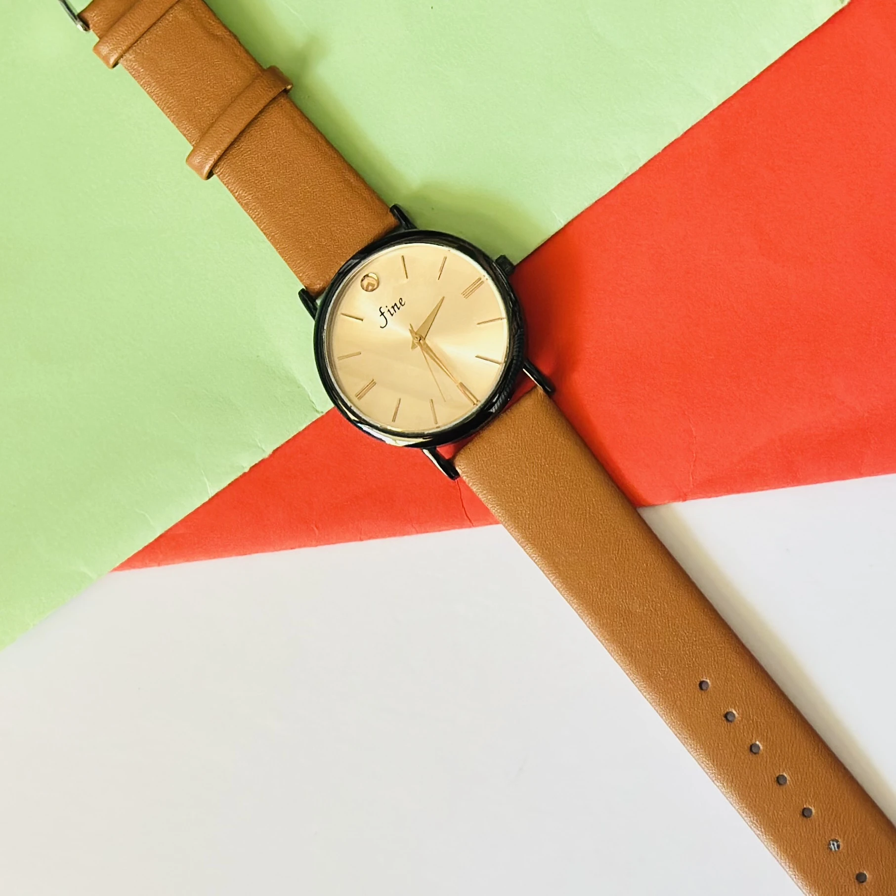 Analog wristwatch with a gold-tone case and a brown leather strap.