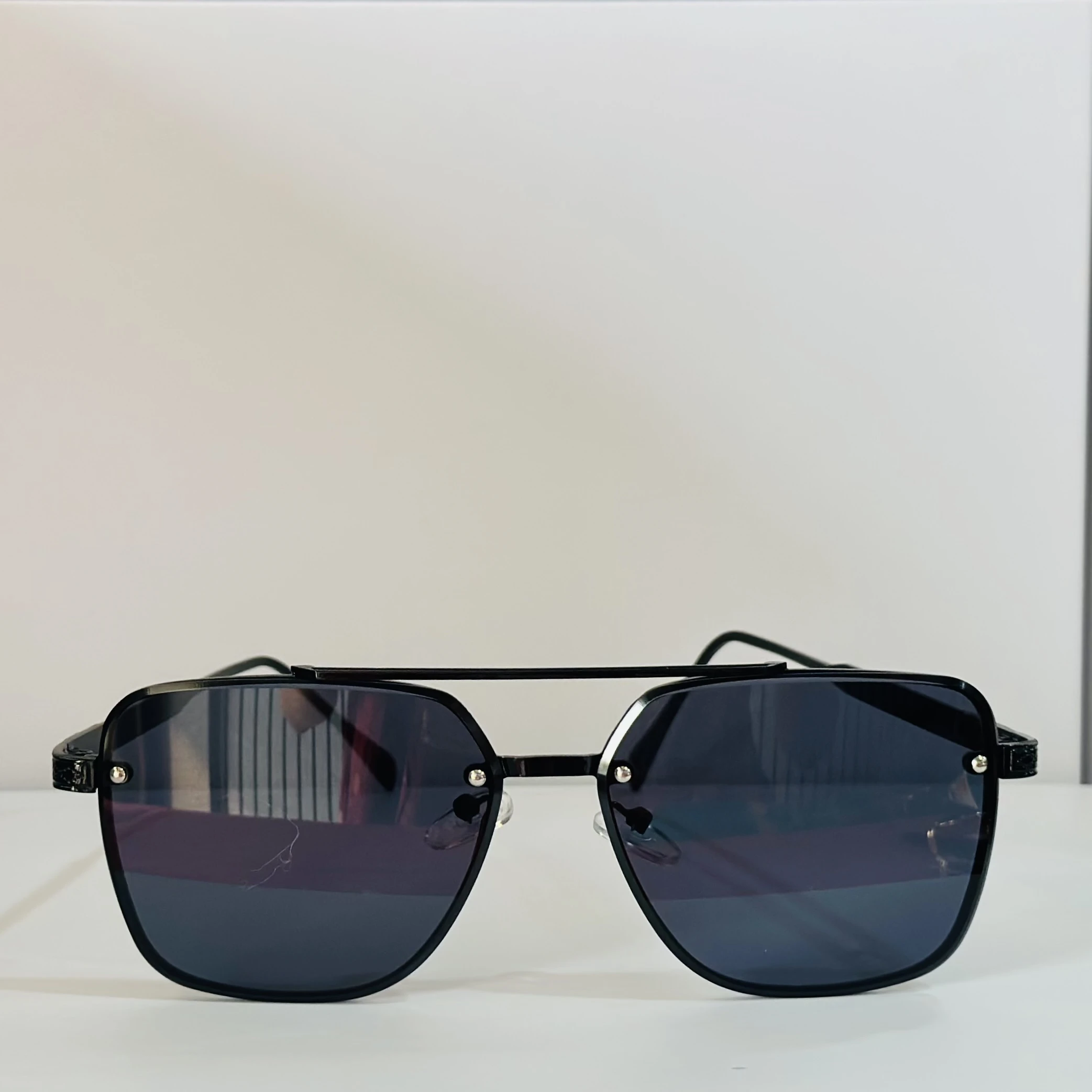 pair of MOONX Celebrity black UV protected sunglasses with a black frame.