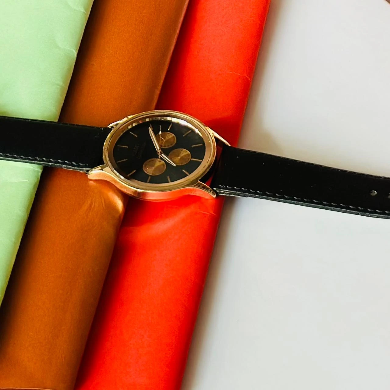 Round analog watch with a black leather strap