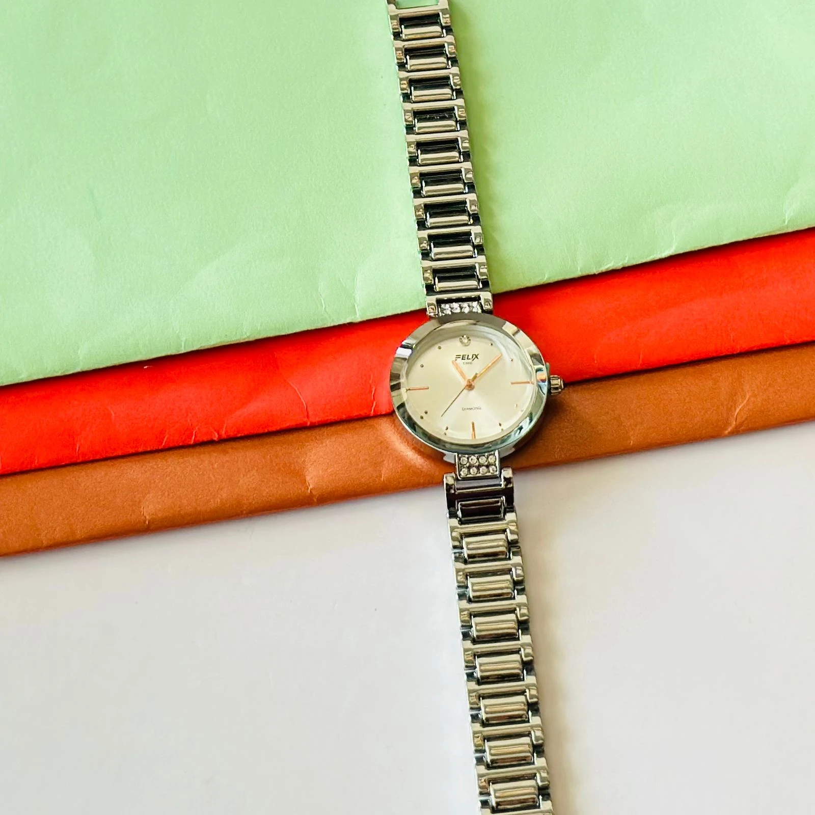 analog watch with a white dial and a rose gold metal strap