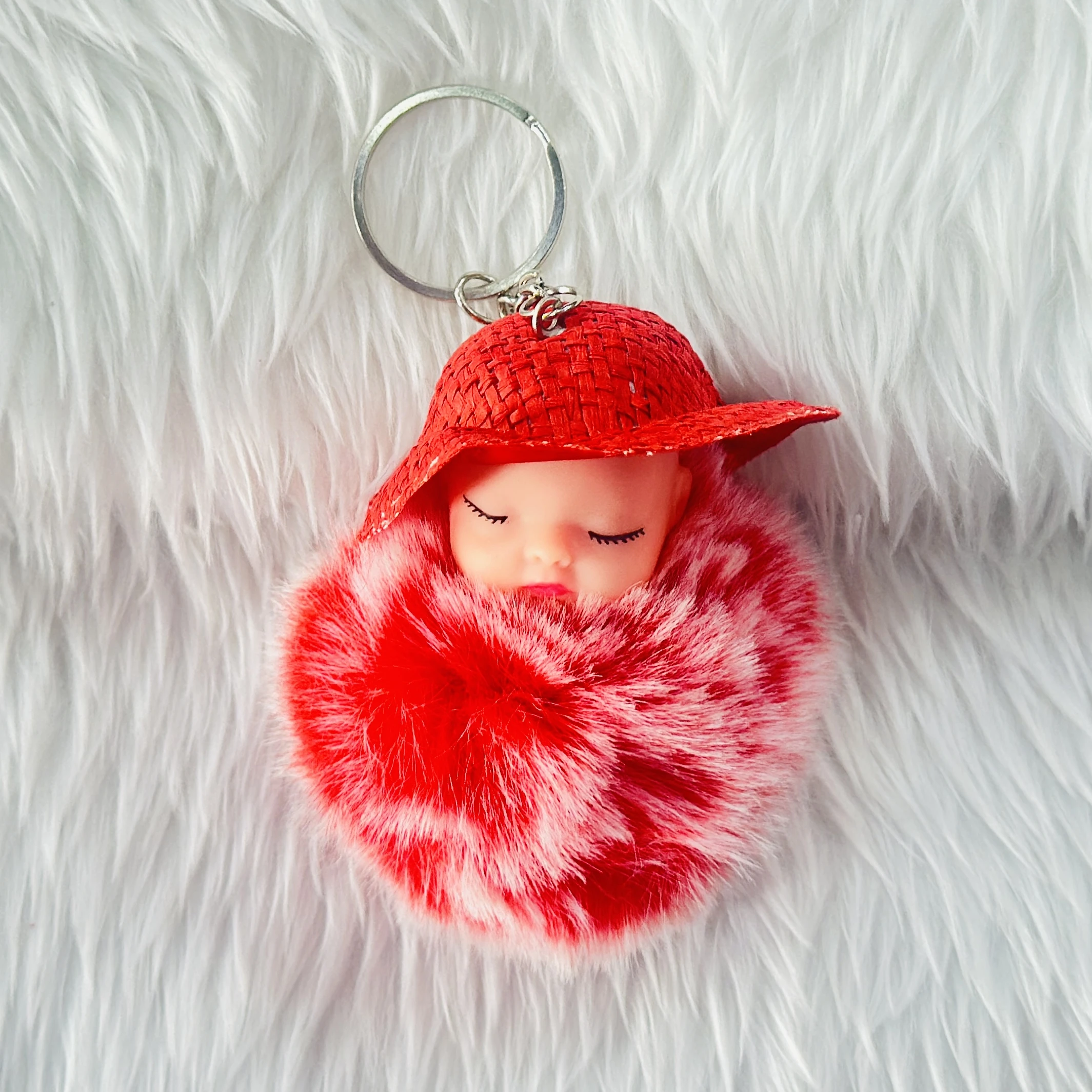 fluffy charm is a red and white SRG sleeping baby doll keychain