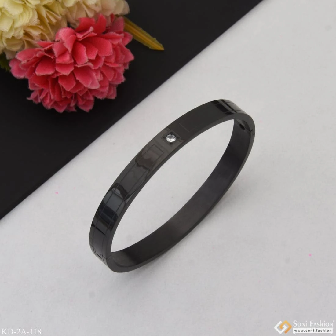 Black stainless steel kada bracelet with a single crystal accent.