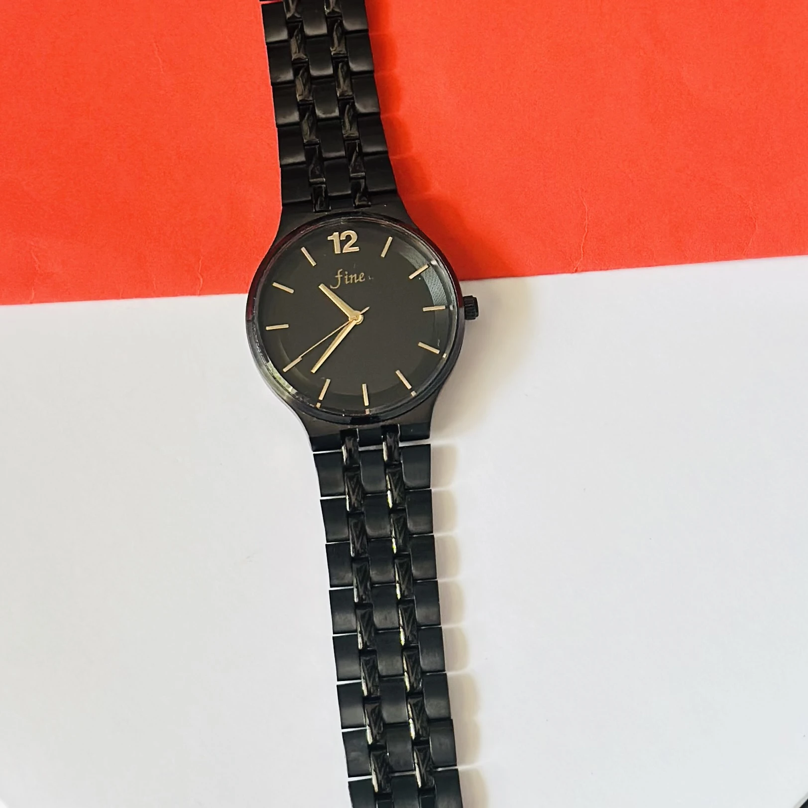 Analog watch with a black stainless steel bracelet and black dial.