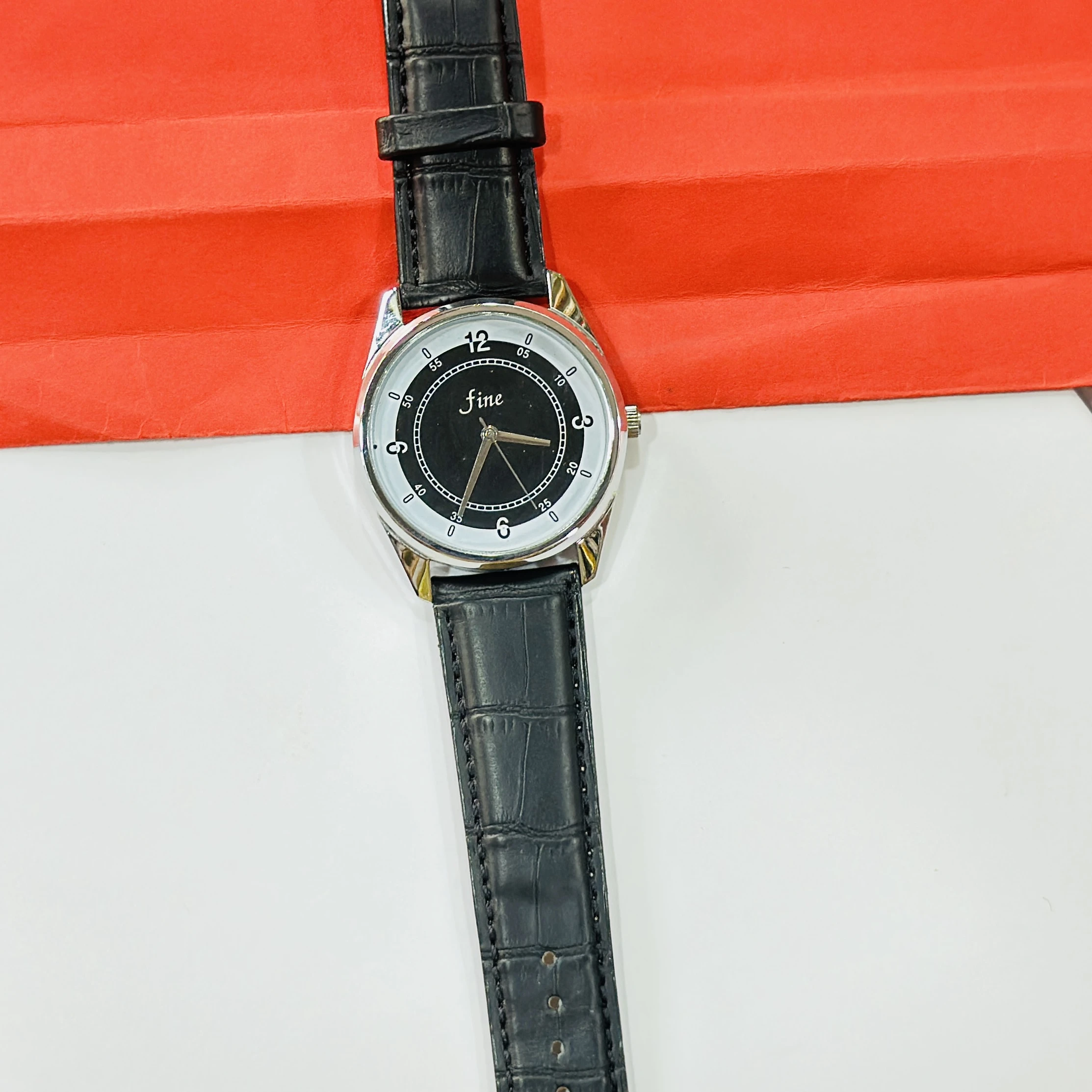 wrist watch with a black leather band and a silver-toned case.