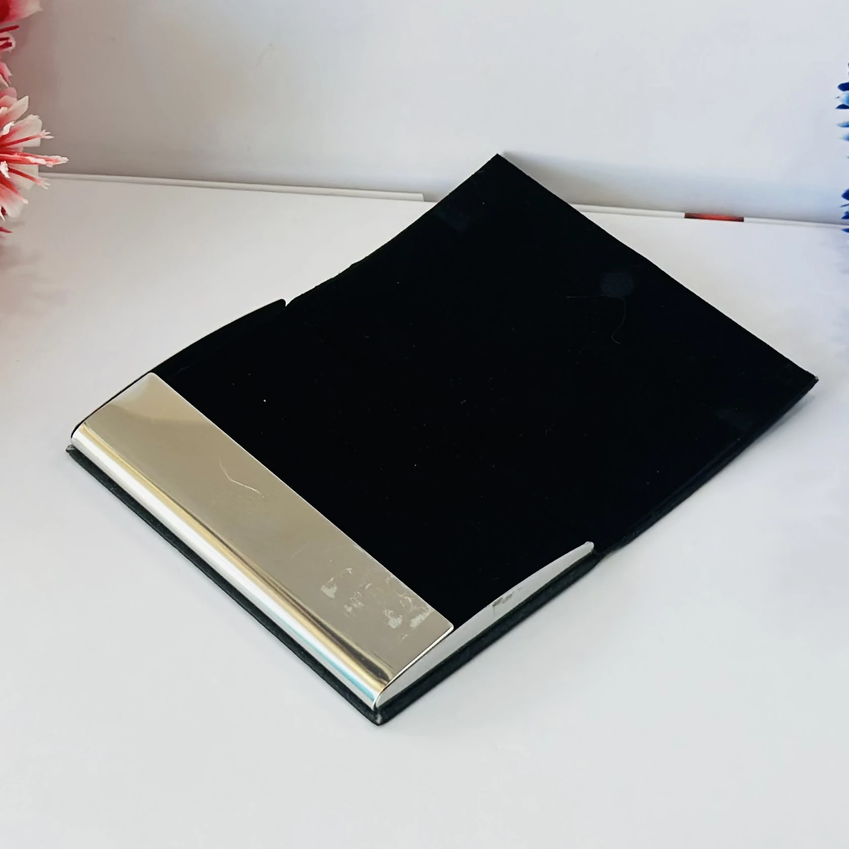 Black faux leather and metal business card holder.