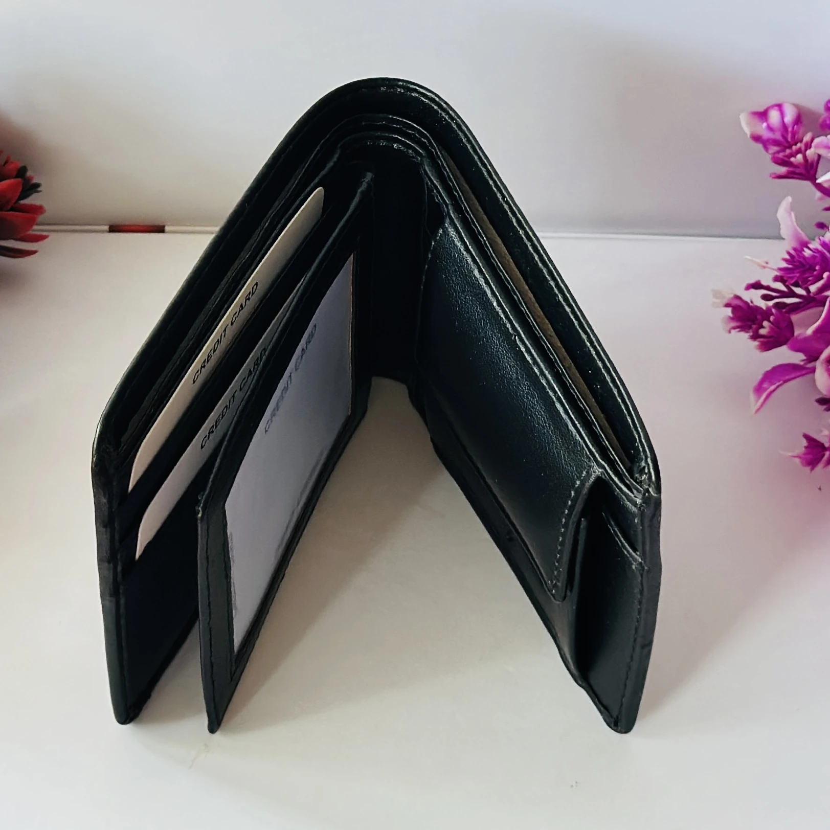 Ferragamo Gancini bi-fold wallet in black calf leather.