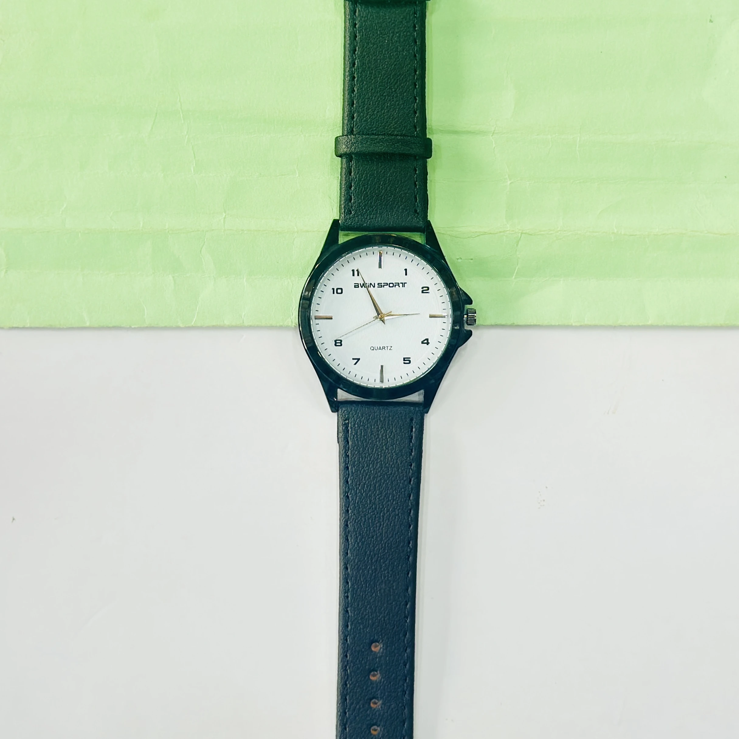 analog watch featuring a white dial, black strap, and quartz movement.
