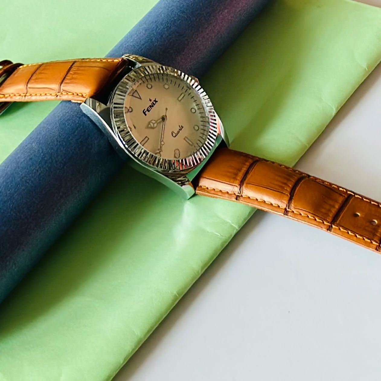 Round analog watch with a brown leather strap