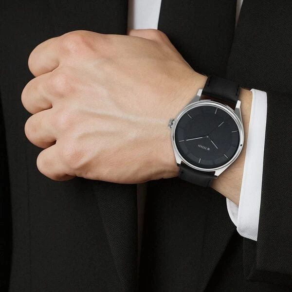 Titan analog wristwatch with a round black dial and a black leather strap