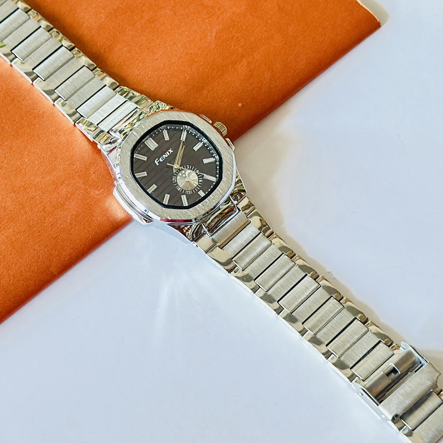 Fenix analog watch featuring a silver-tone stainless steel strap and a black dial.