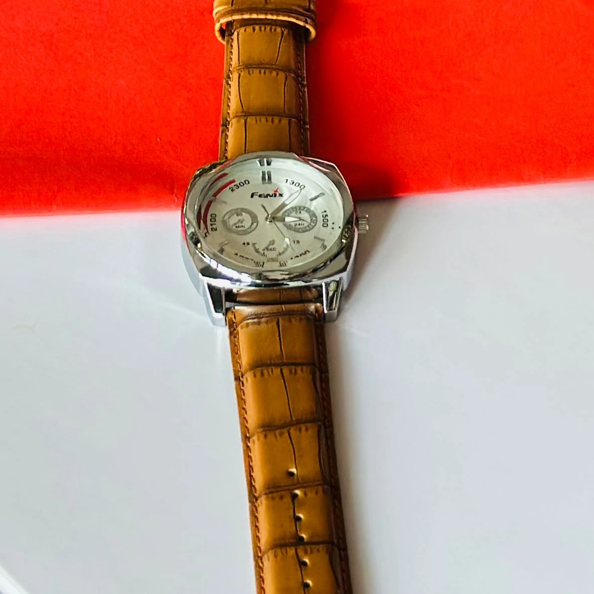 Round analog watch with a brown leather strap