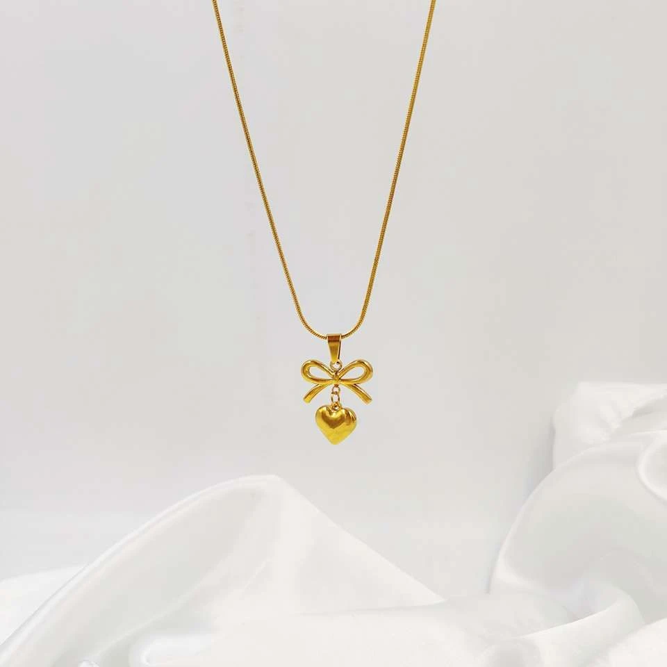 Lumora Forever Gleaming necklace features a heart and bow pendant
