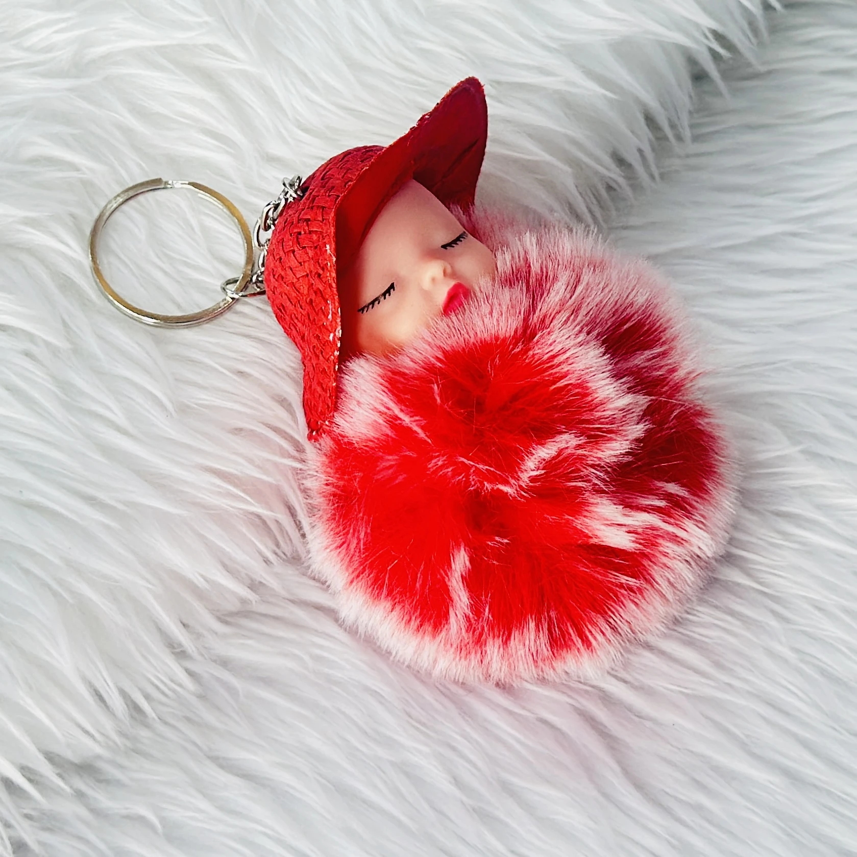 fluffy charm is a red and white SRG sleeping baby doll keychain