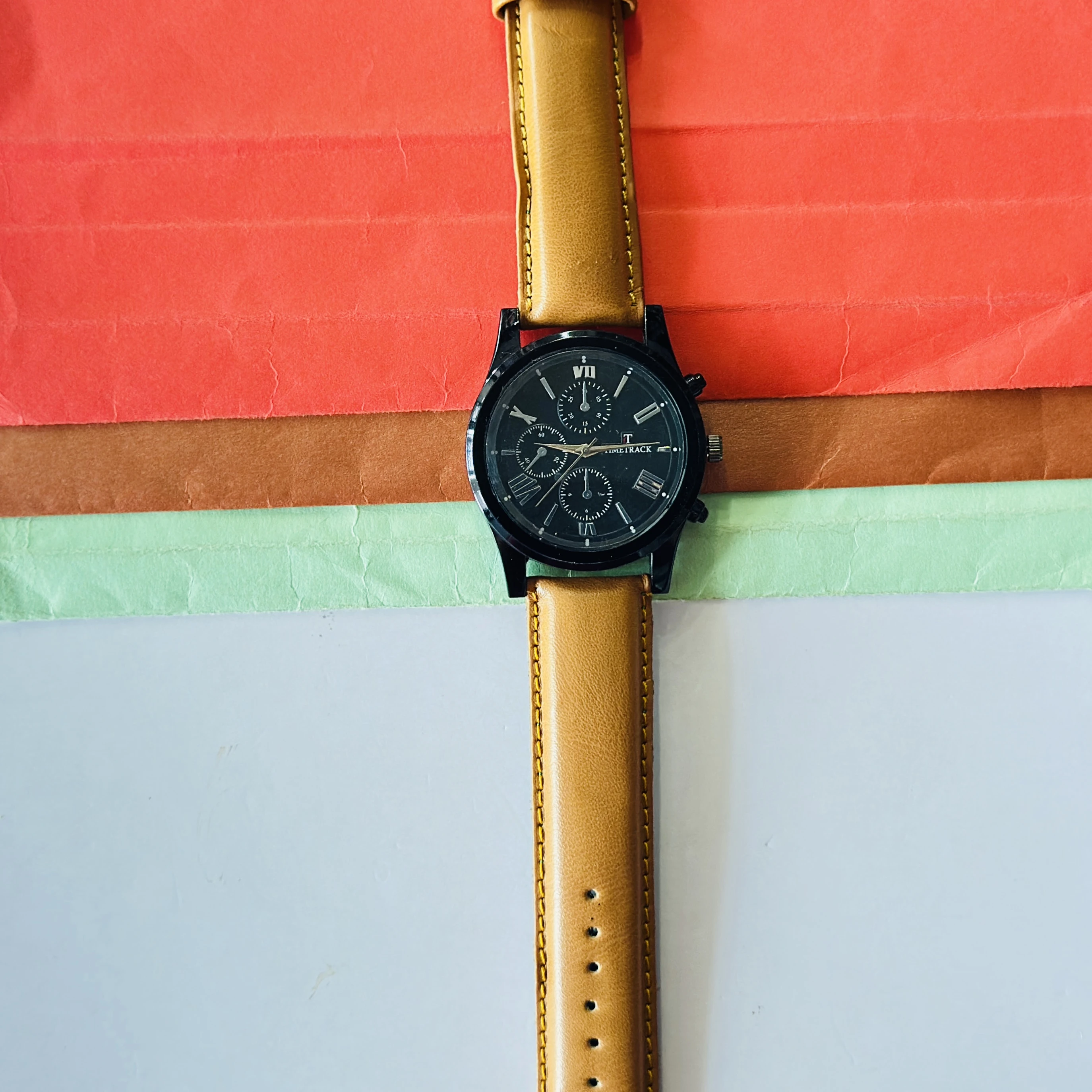 Timetrack quartz analog watch with a black dial and a brown leather strap.
