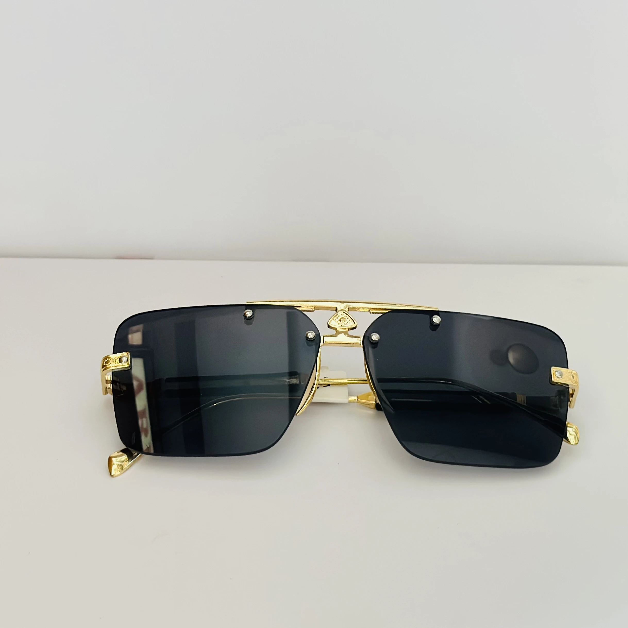 Maybach square gold-framed sunglasses with black lenses.