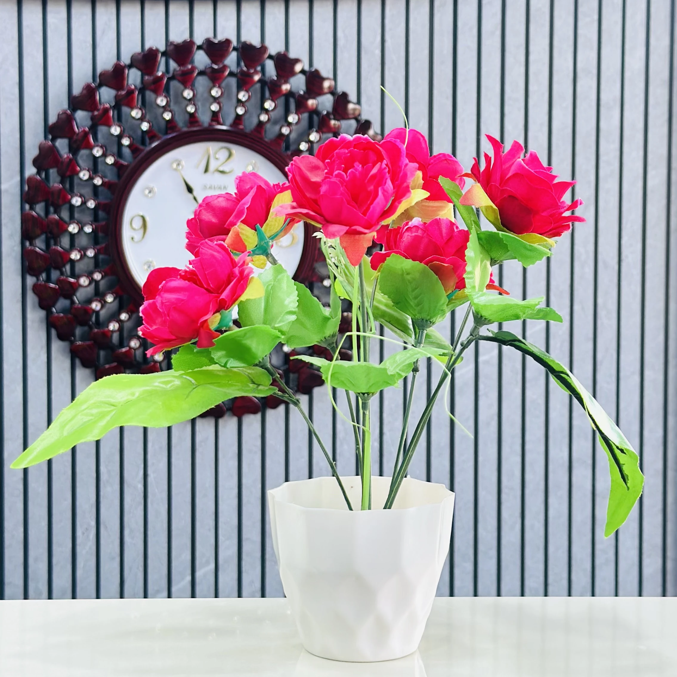Red rose flower arrangement in a white pot.