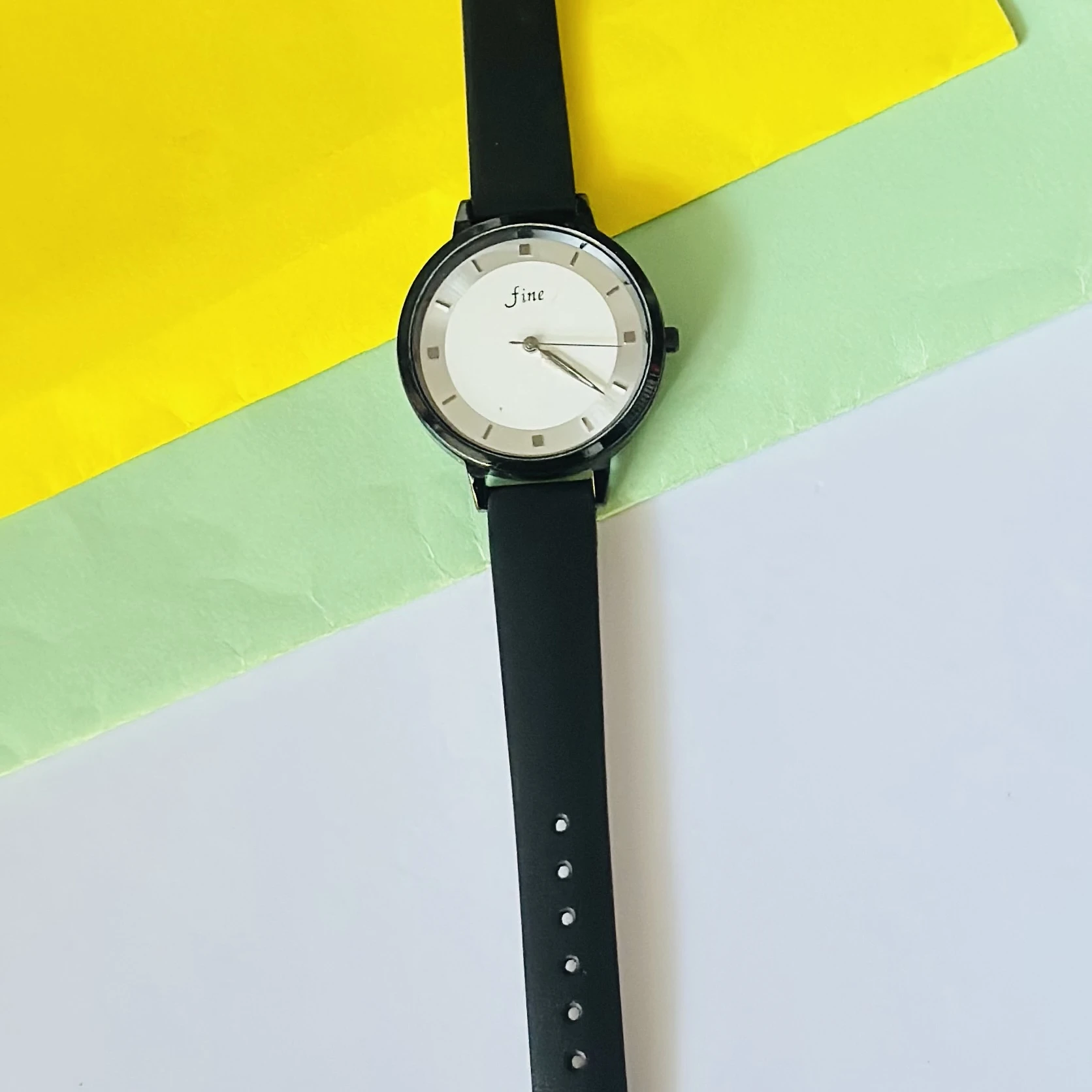 Black analog wristwatch with a black faux leather strap.