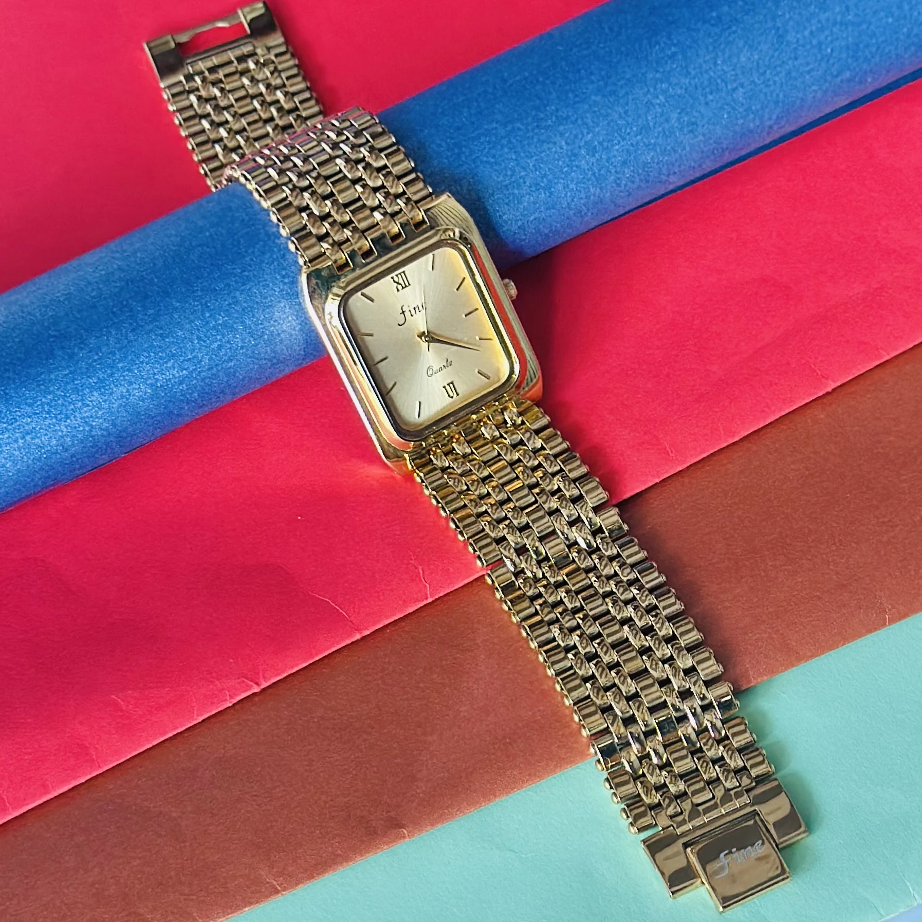 Gold -tone analog quartz watch with a metal strap.