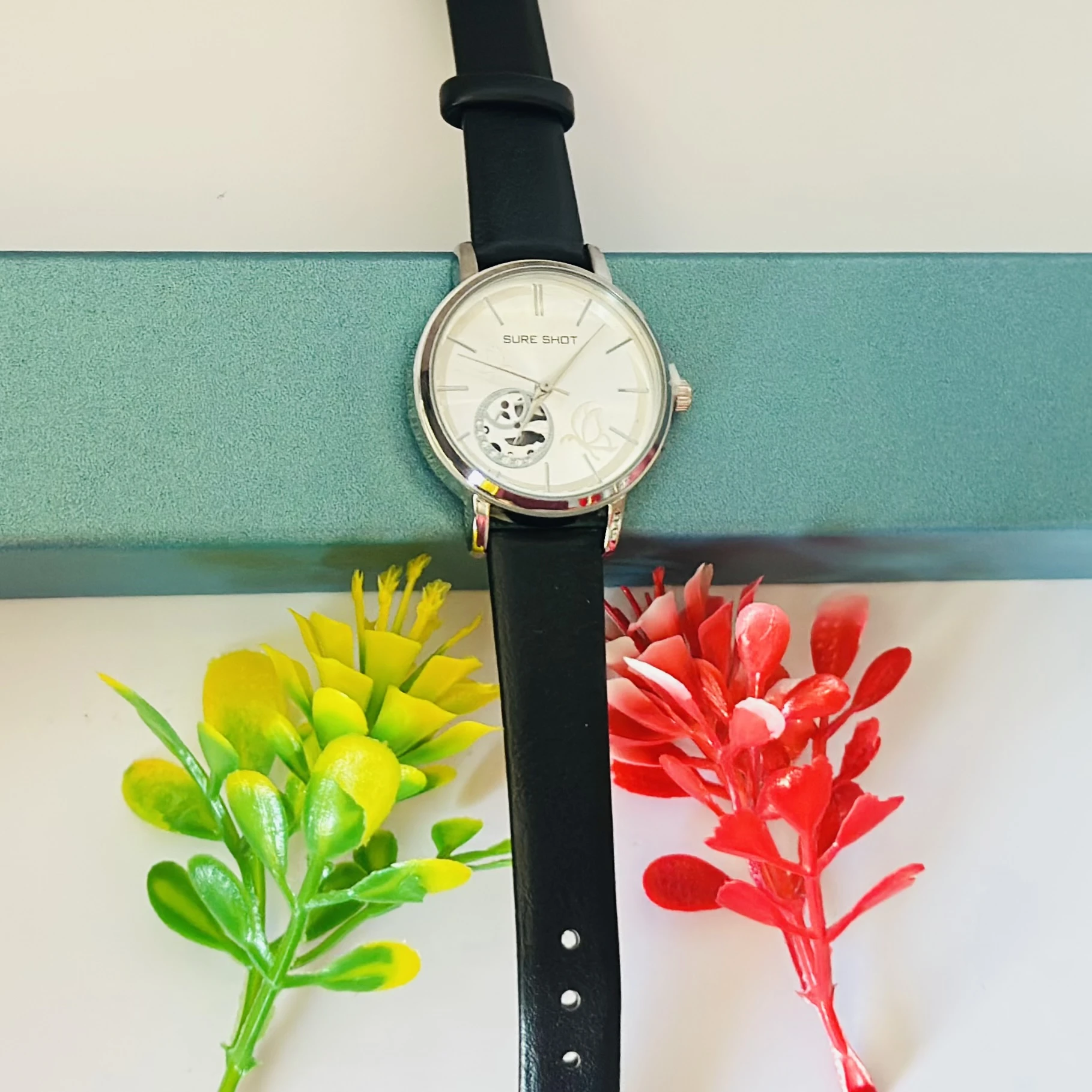 Sure Shot analog watch with a black leather band and silver-tone case.