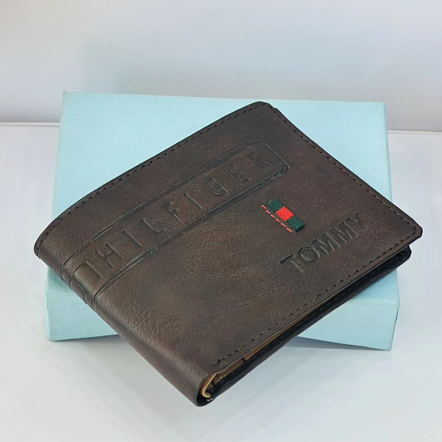 a Tommy Hilfiger men's brown leather bifold wallet.