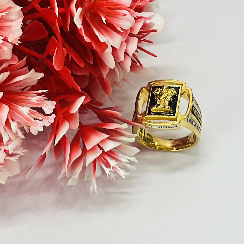 Gold -toned men's signet ring with black accent stones and engraved text.