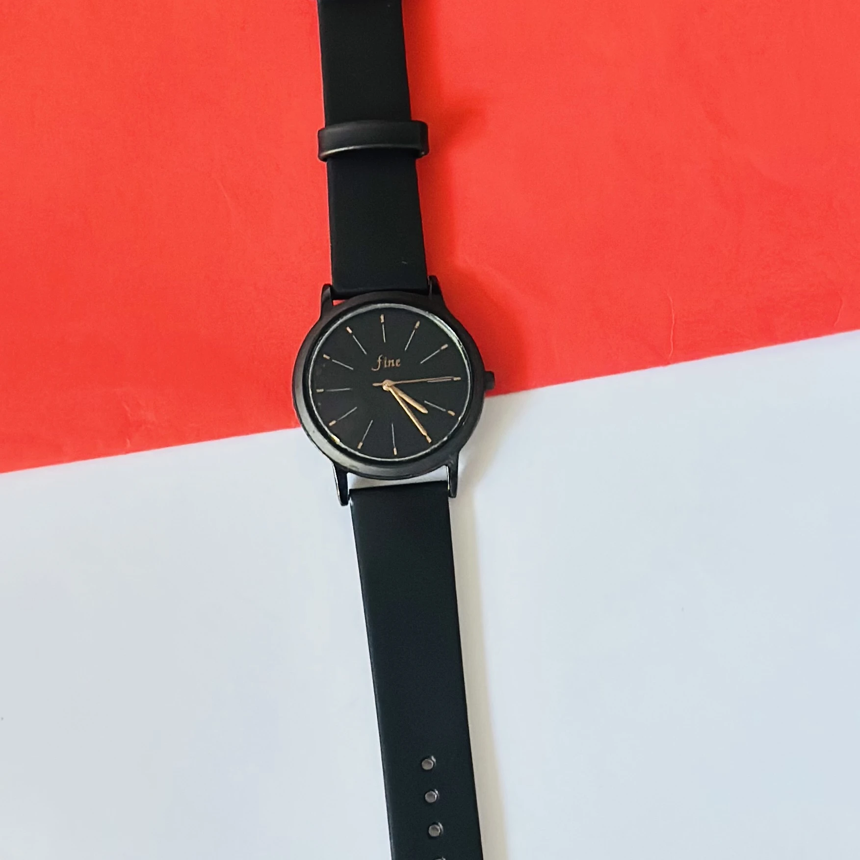women's analog watch in black with a silicone strap.